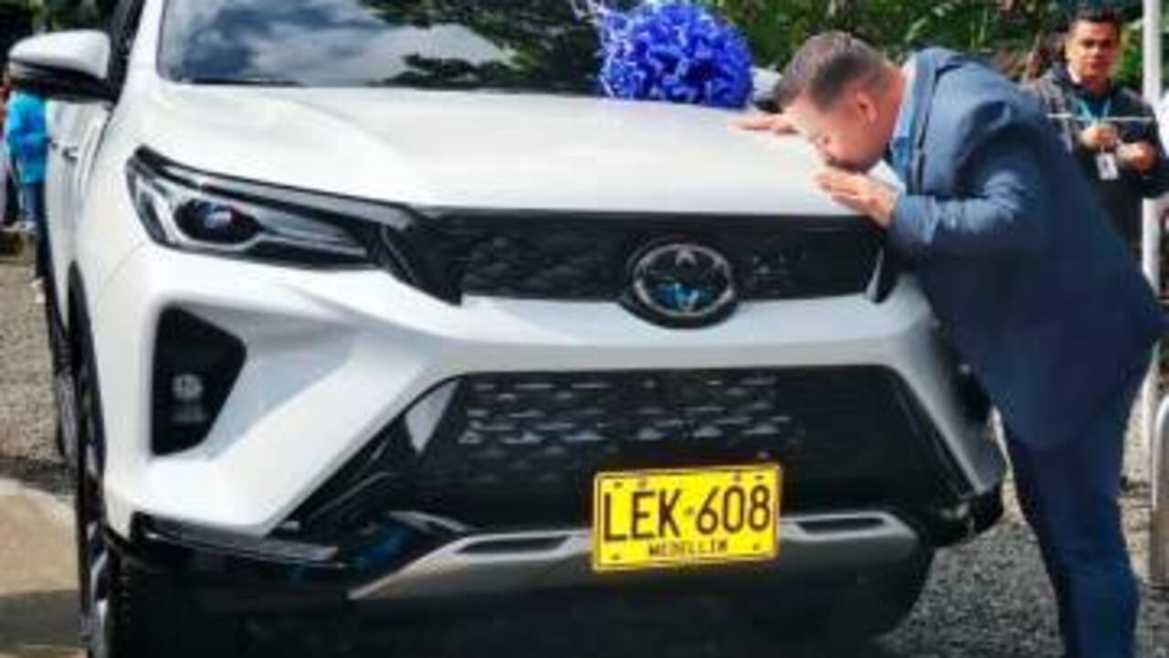 Personero de Medellín dándole un beso a una camioneta de la entidad.