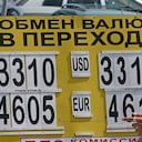 En Moscú personas miran las tasas cambiarias del rublo frente al dólar después de que la moneda rusa se desplomara a su nivel más bajo en los últimos dos meses. Se debe principalmente a la acelerada caída en los precios del petróleo.