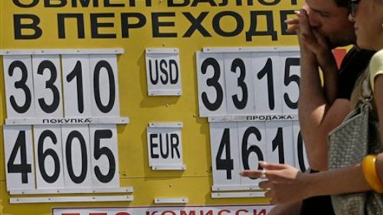 En Moscú personas miran las tasas cambiarias del rublo frente al dólar después de que la moneda rusa se desplomara a su nivel más bajo en los últimos dos meses. (Archivo Semana)