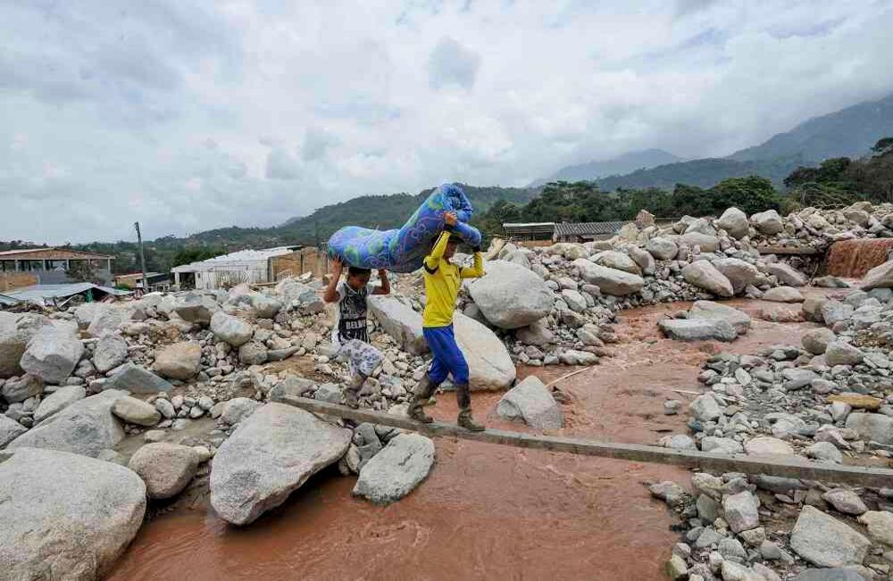 Dos niños cargan una colchoneta en medio de miles de rocas dejadas por una avalancha, el miércoles 5 de abril de 2017 en Mocoa, Putumayo, la noche del 31 de marzo. El desastre fue producido por el desbordamiento de los ríos Mocoa, Mulato y Sangoyaco dejando hasta el momento 301 víctimas mortales y un indeterminado numero de desaparecidos. Foto: Carlos Julio Martínez / Enviado Especial de Semana
