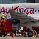 Los trabajadores cubren partes del motor de un avión con plástico para evitar que las cenizas volcánicas ingresen al aeropuerto internacional La Aurora, que fue cerrado debido a una erupción en el volcán Pacaya en la Ciudad de Guatemala, el martes 23 de marzo de 2021 (AP Photo / Moises Castillo). )