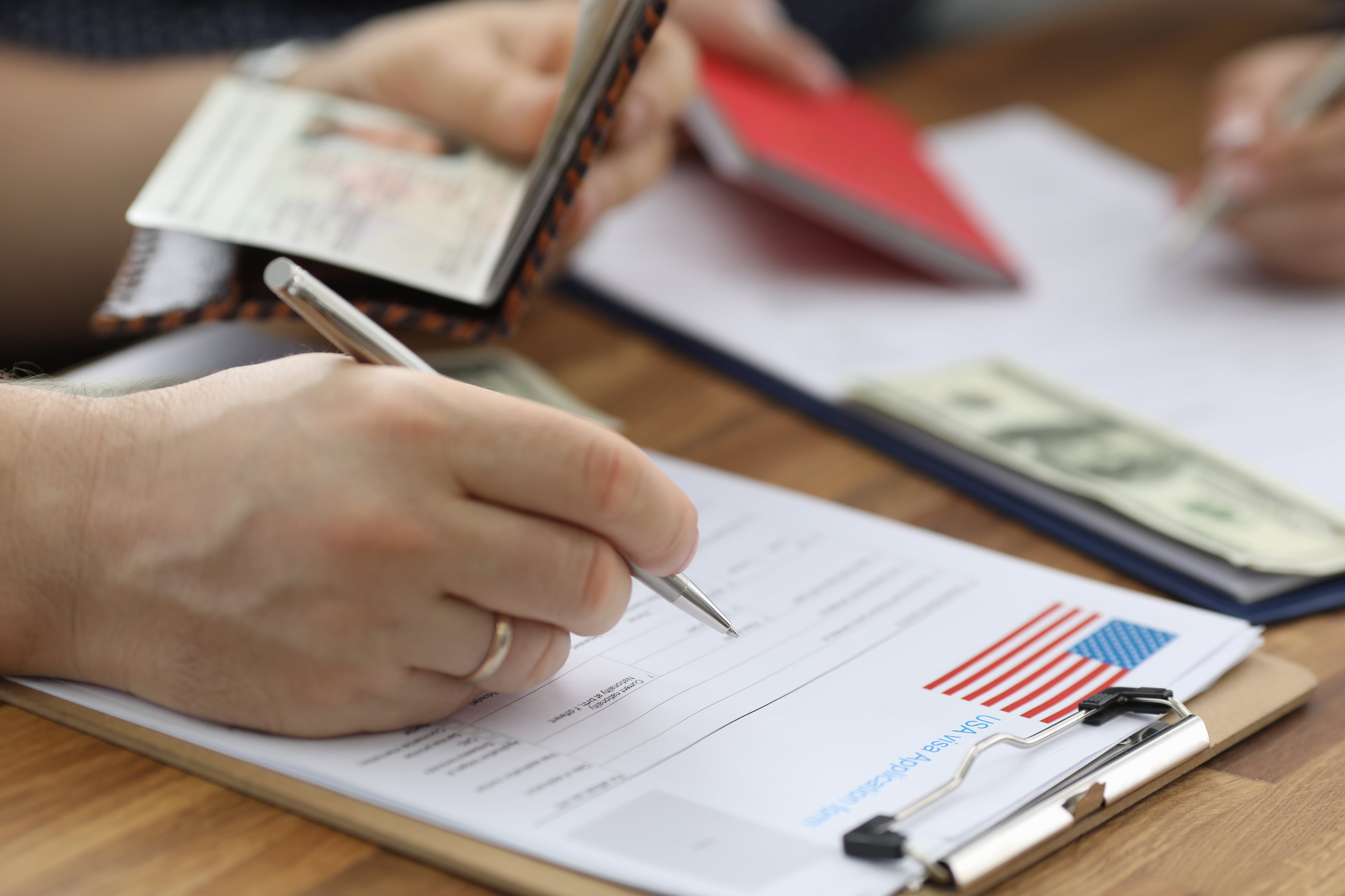 Close-up of person carry information from passport to usa visa application form. Man planning to move abroad. International and legal immigration concept