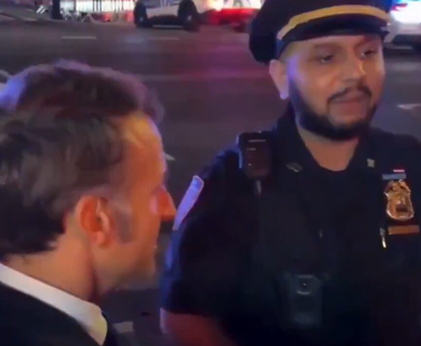 Emmanuel Macron hablando con uno de los policías que detenía el tráfico