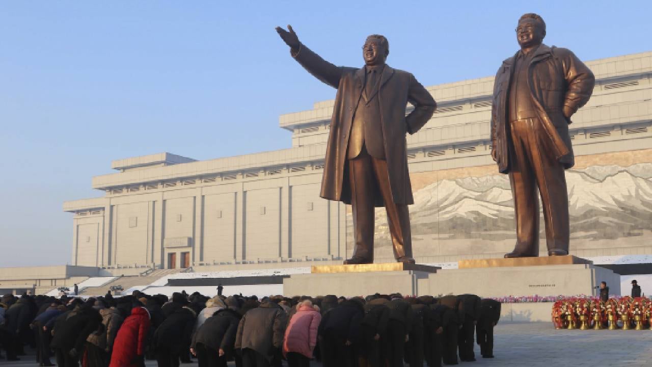 La gente se inclina ante las estatuas de los exlíderes, Kim Il Sung, y Kim Jong Il en Mansu Hill con motivo del 11° aniversario de la muerte de Kim Jong Il