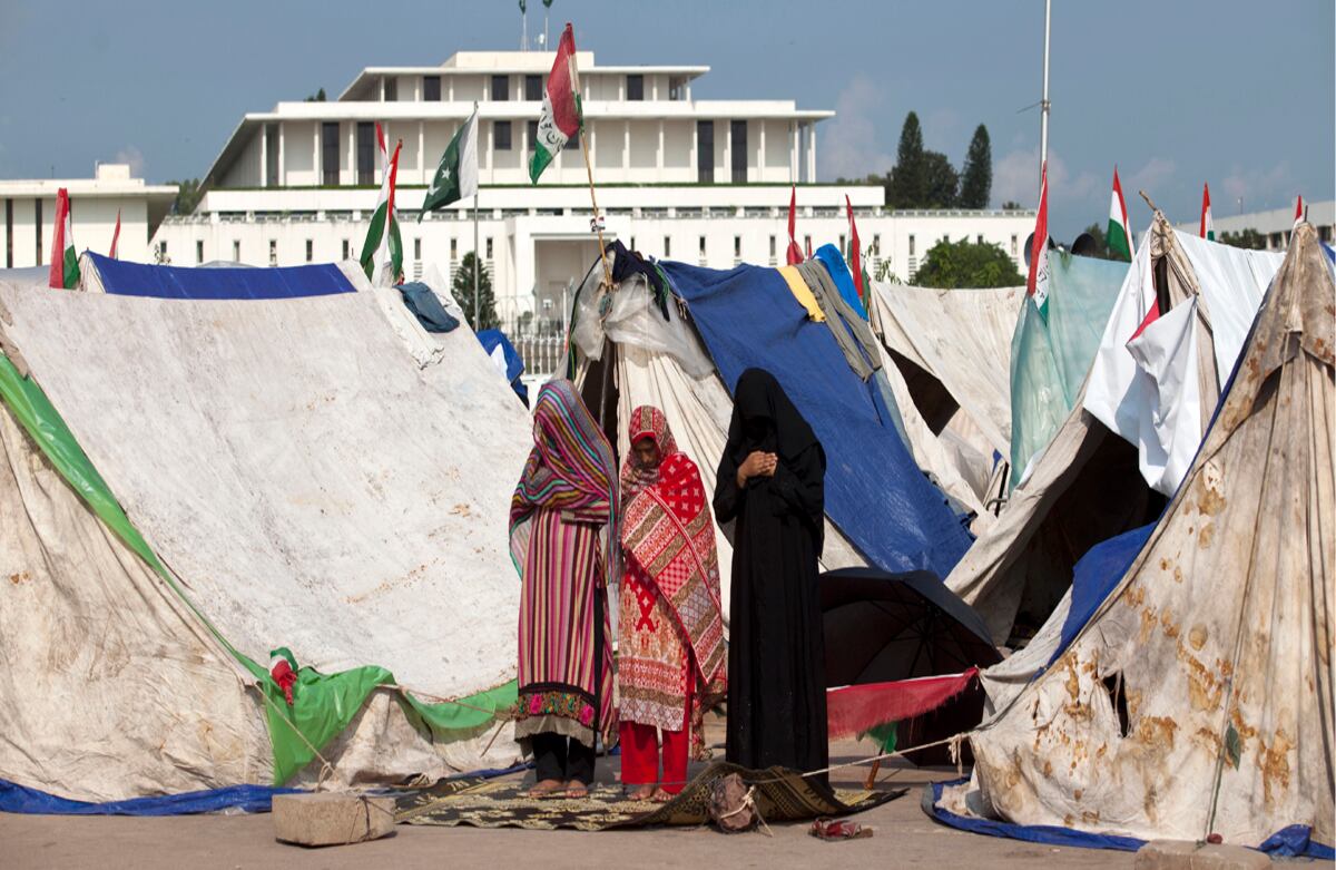 Mujeres paquistaníes realizan plegarias en un campamento afuera del edificio del parlamento en Islamabad, Paquistán, este viernes doce de septiembre.