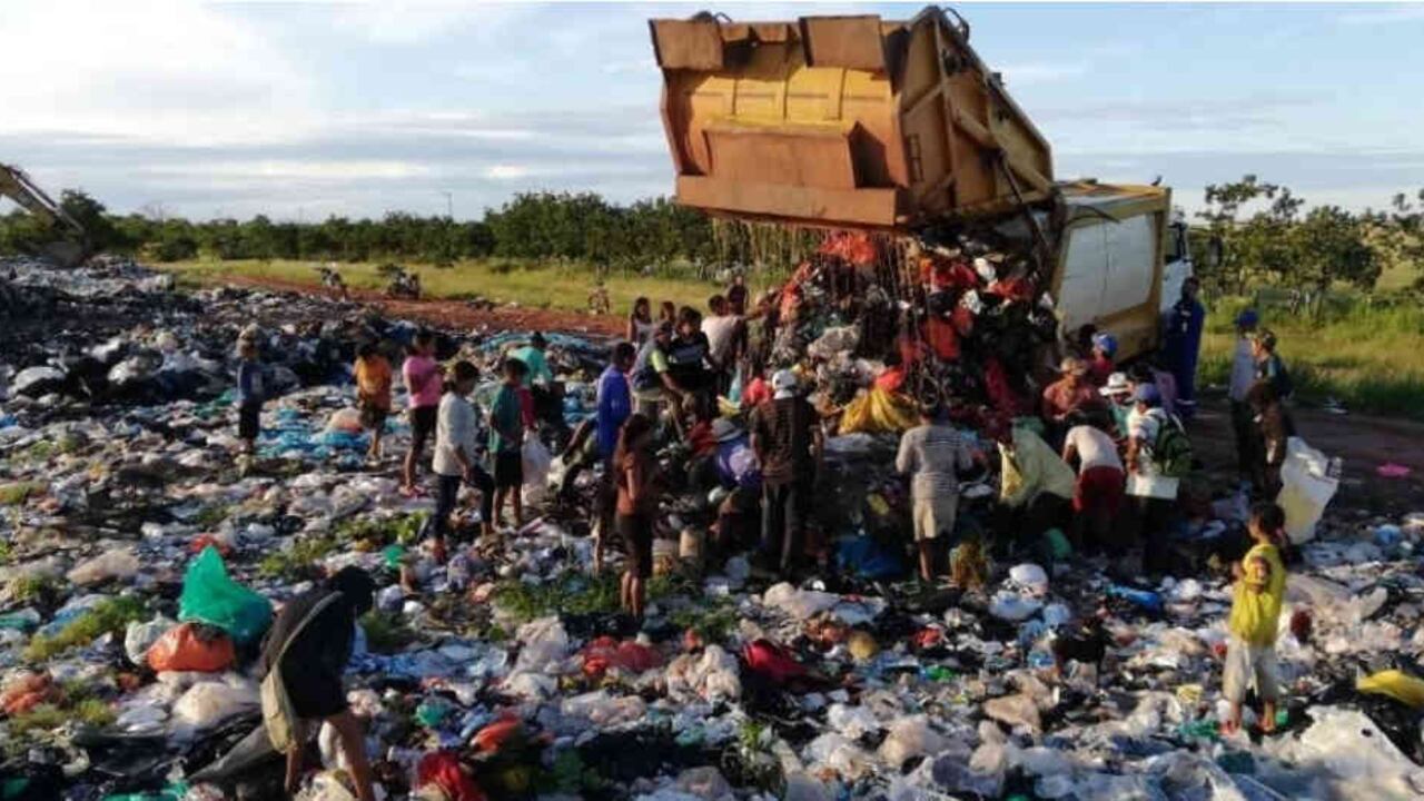 Varias mujeres y niños estaban escarbando en la basura para obtener alimento.