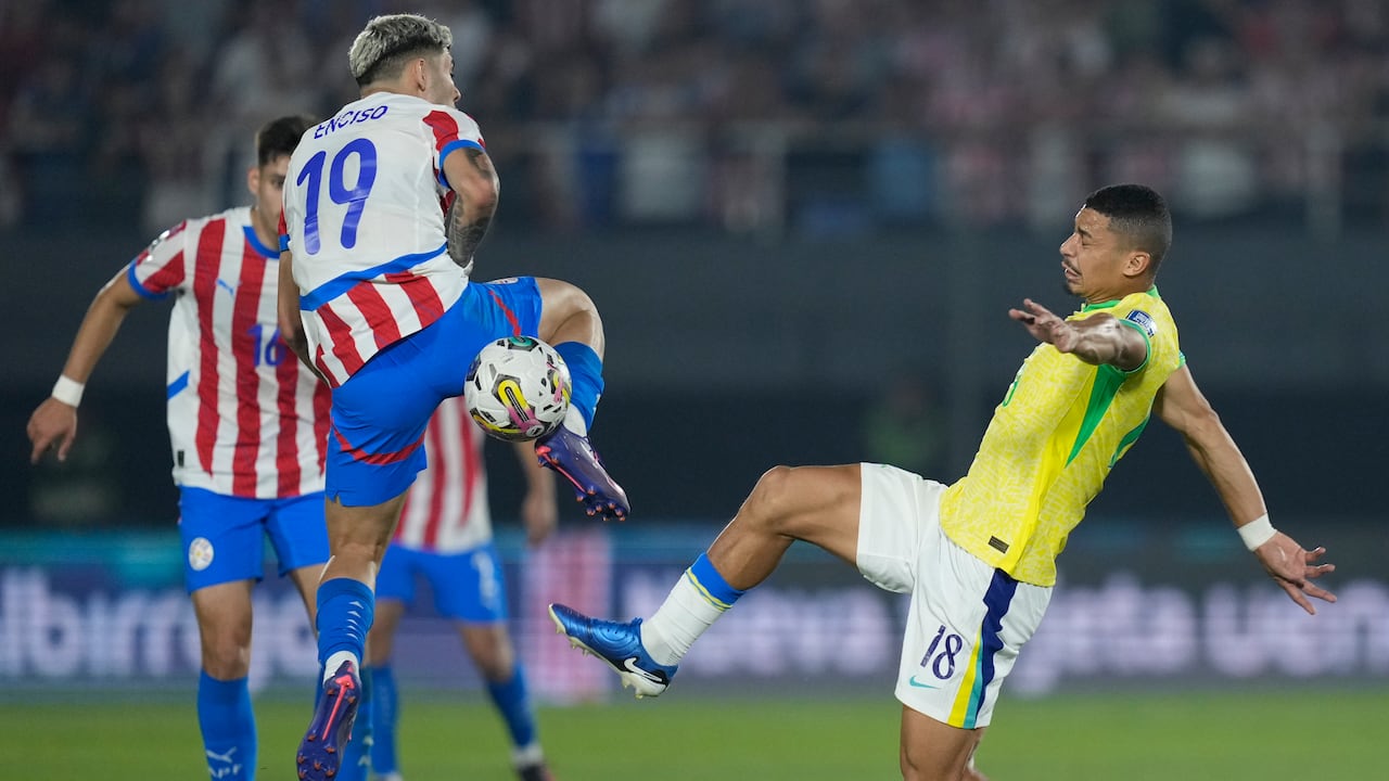 André de Brasil, derecha, y Julio Enciso de Paraguay luchan por el balón durante un partido de fútbol de clasificación para la Copa Mundial de la FIFA 2026 en el Estadio Defensores del Chaco, en Asunción, Paraguay, el martes 10 de septiembre de 2024. (Foto AP/Jorge Saenz )