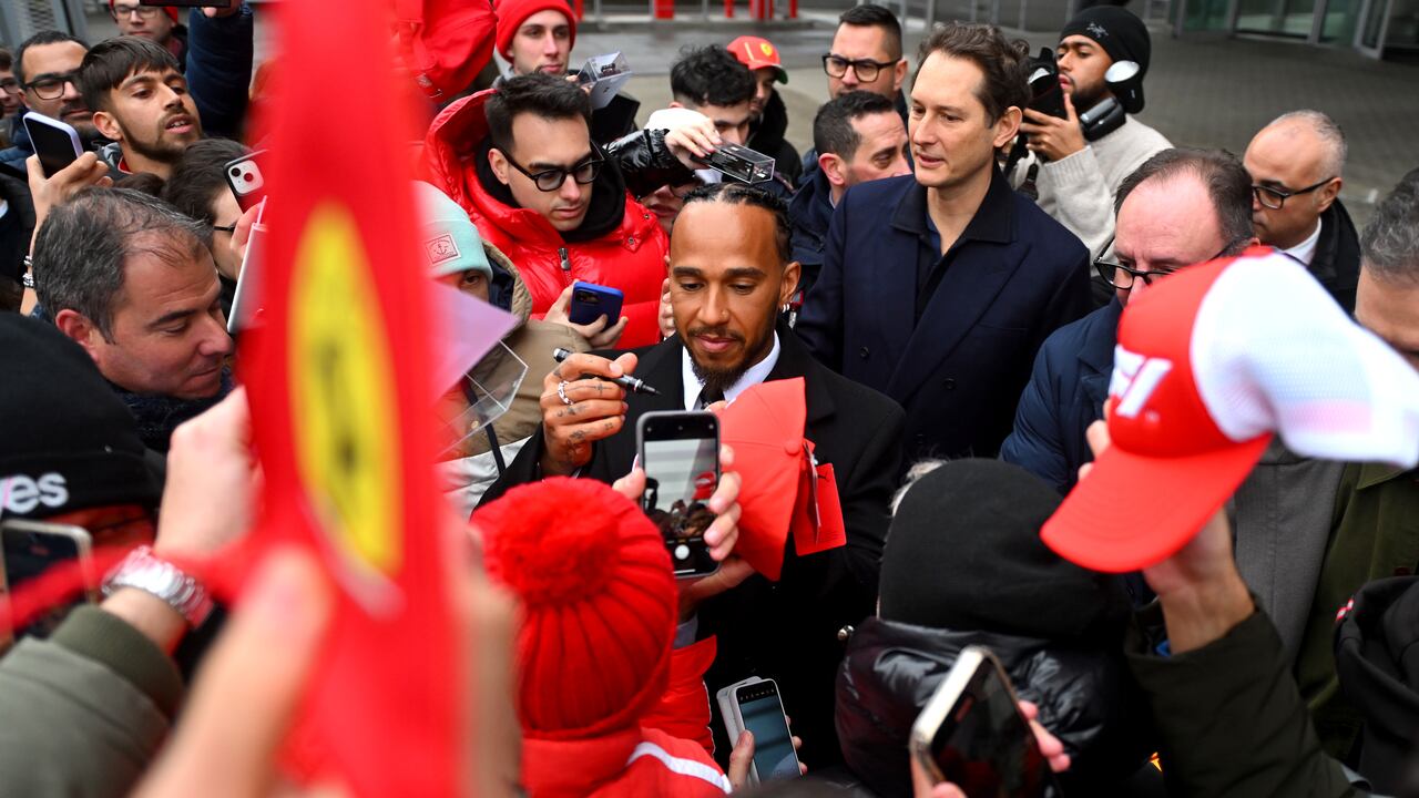 Sir Lewis Hamilton saluda a los aficionados durante sus primeros días oficiales como piloto de F1 de la Scuderia Ferrari en el Circuito de Fiorano mientras John Elkann, CEO de Exor, observa, el 20 de enero de 2025 en Fiorano Modenese, Italia.