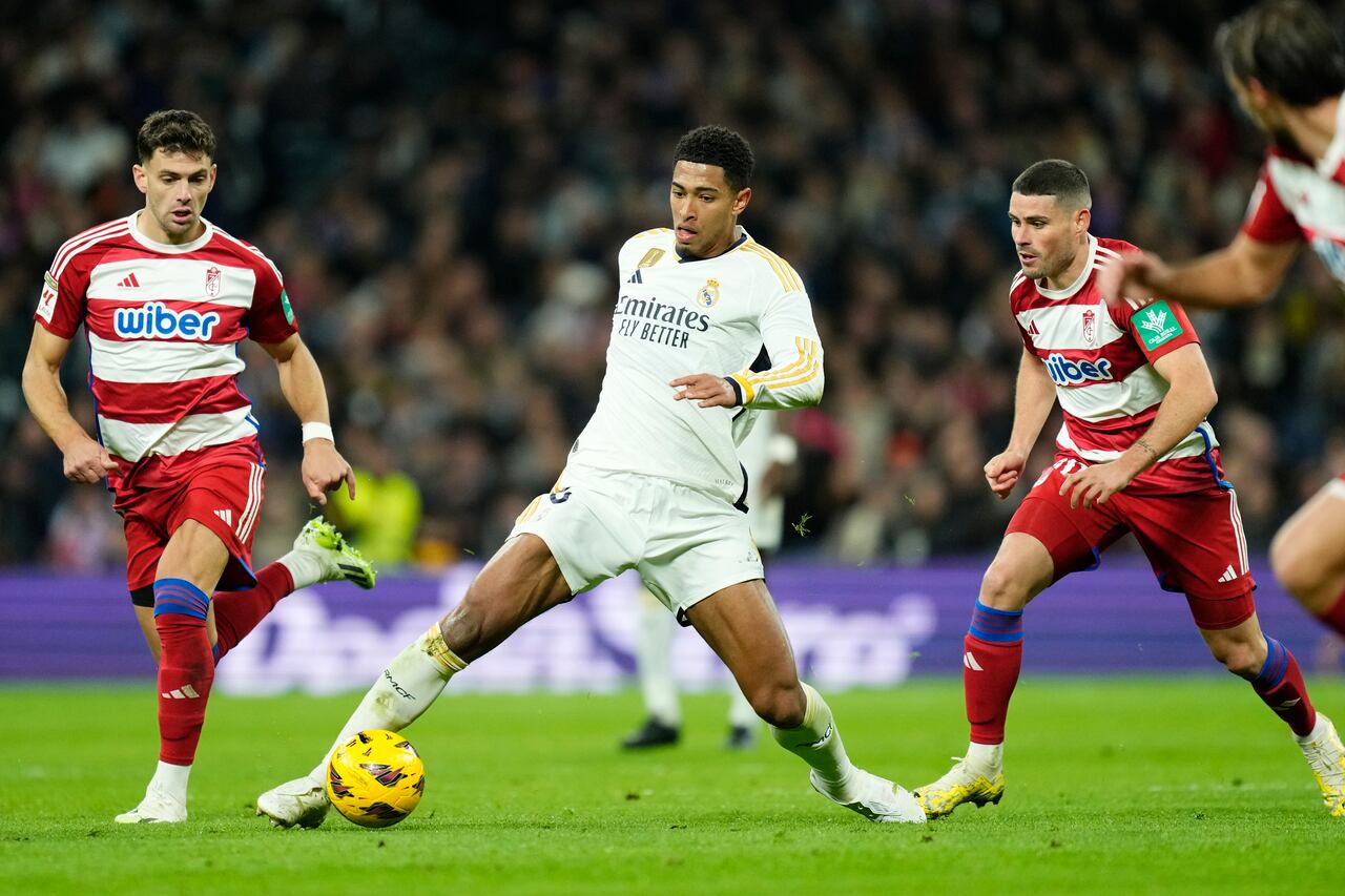 Jude Bellingham del Real Madrid, en el centro, en acción durante el partido de fútbol de la Liga española entre Real Madrid y Granada en el estadio Santiago Bernabeu en Madrid, España, el sábado 2 de diciembre de 2023. (Foto AP/José Bretón)