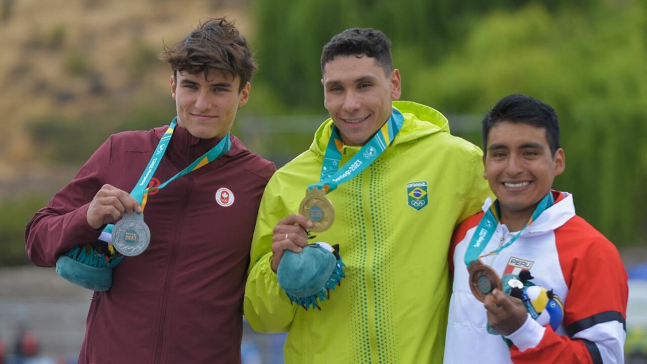 (De izquierda a derecha) Alex Baldoni, de Canadá; Guilherme Mapelli, de Brasil y Eriberto Gutiérrez, de Perú; suben al podio con sus medallas de plata, oro y bronce, respectivamente, en la final de kayak cross K1 masculino durante los Juegos Panamericanos Santiago 2023, en el río Aconcagua. en Los Andes, Región de Valparaíso, Chile, el 29 de octubre de 2023. (Foto de Guillermo SALGADO/AFP)