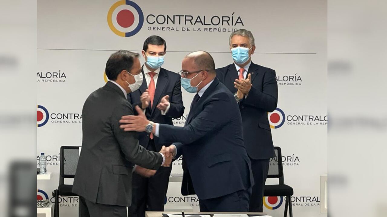 Pablo Andrés Jackson, CEO de Seguros Mapfre para Colombia ( a la izquierda), estrecha la mano de Jorge Andrés Carrillo Cardoso, gerente general de EPM. Al fondo, de derecha izquierda, el contralor Carlos Felipe Córdoba y el presidente Iván Duque