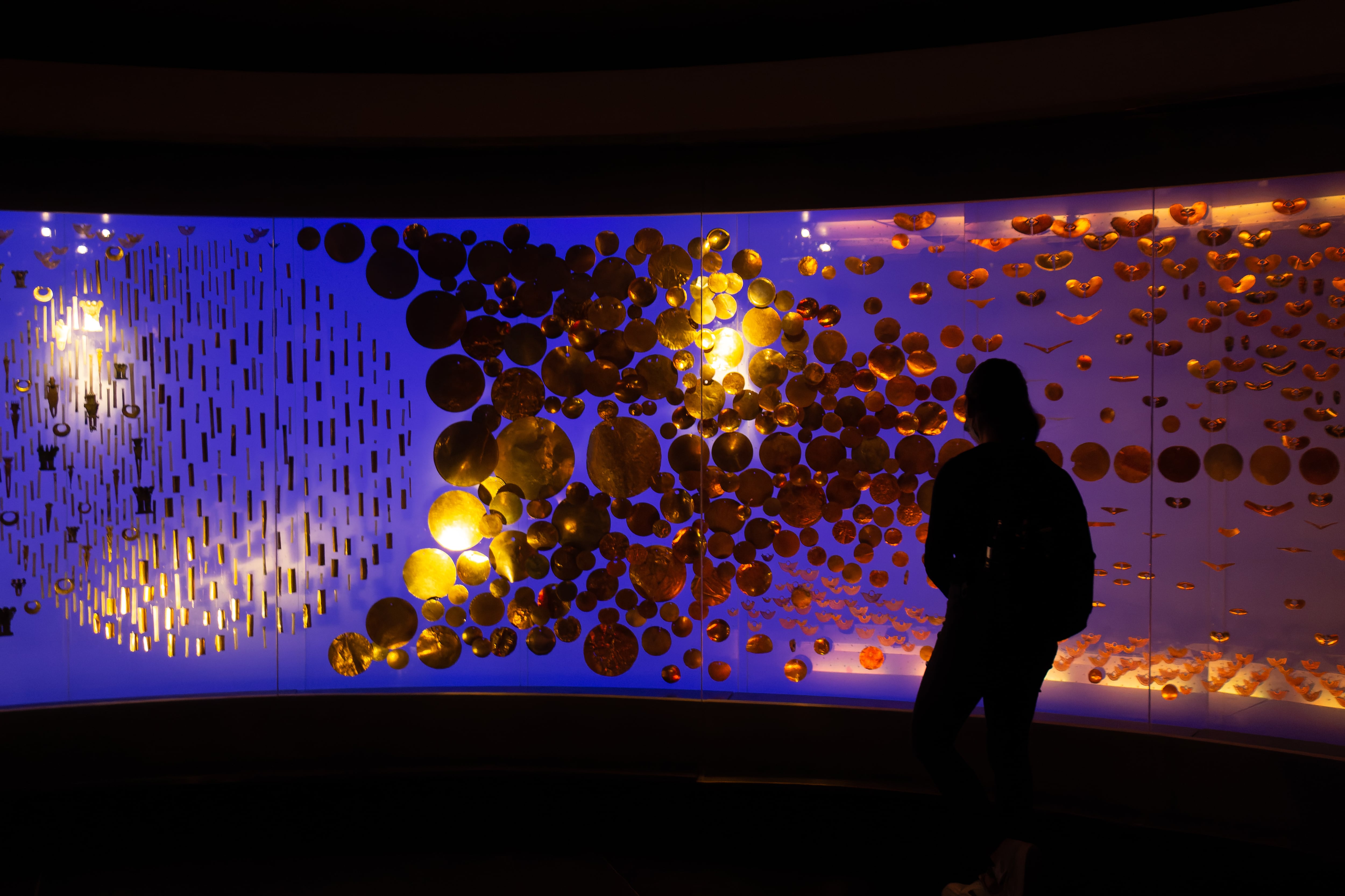 Bogota, Colombia, February 06 2023 : tourist admiring pre-columbian gold artifacts on display in the museo del oro. The museum of gold is located in Bogotá, Colombia.
