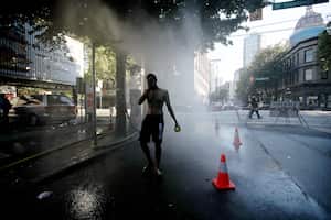 Un residente camina a través de una estación de nebulización temporal en Abbott Street durante una ola de calor en Vancouver, Columbia Británica, Canadá, el lunes 28 de junio de 2021. Se espera que el calor continúe durante varios días en algunas partes de Columbia Británica, según las advertencias meteorológicas. del Gobierno. Fotógrafo: Trevor Hagan / Bloomberg a través de Getty Images
