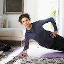 Mujer adulta media haciendo yoga en casa