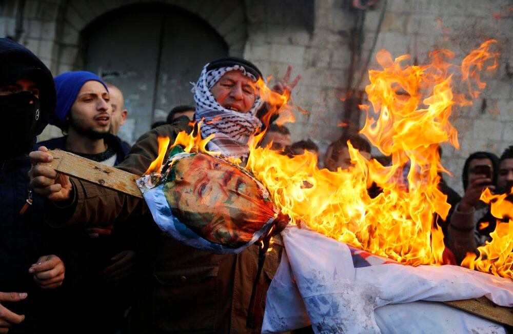 Los manifestantes palestinos queman una efigie del presidente estadounidense Donald Trump después de su decisión de reconocer a Jerusalén como la capital de Israel, en la ciudad cisjordana de Nablus, el 7 de diciembre de 2017. Jaafar ASHTIYEH / AFP