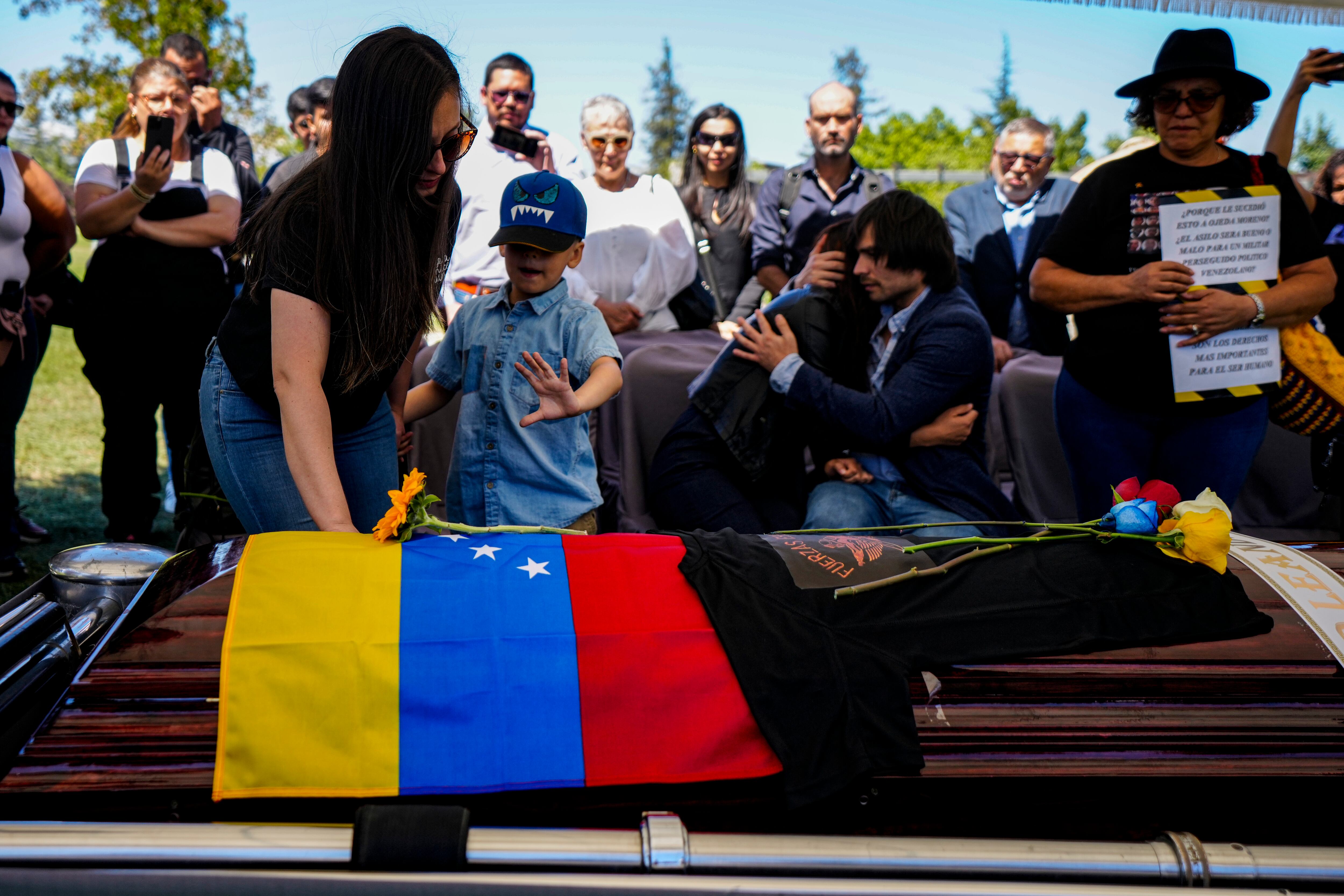 La viuda, el hijo y la hermana del ex militar disidente venezolano Roland Ojeda, lo entierran en el Cementerio de Canaán en Santiago, Chile, el 8 de marzo de 2024, luego de que fuera secuestrado y su cuerpo fuera encontrado enterrado en las afueras de la capital.