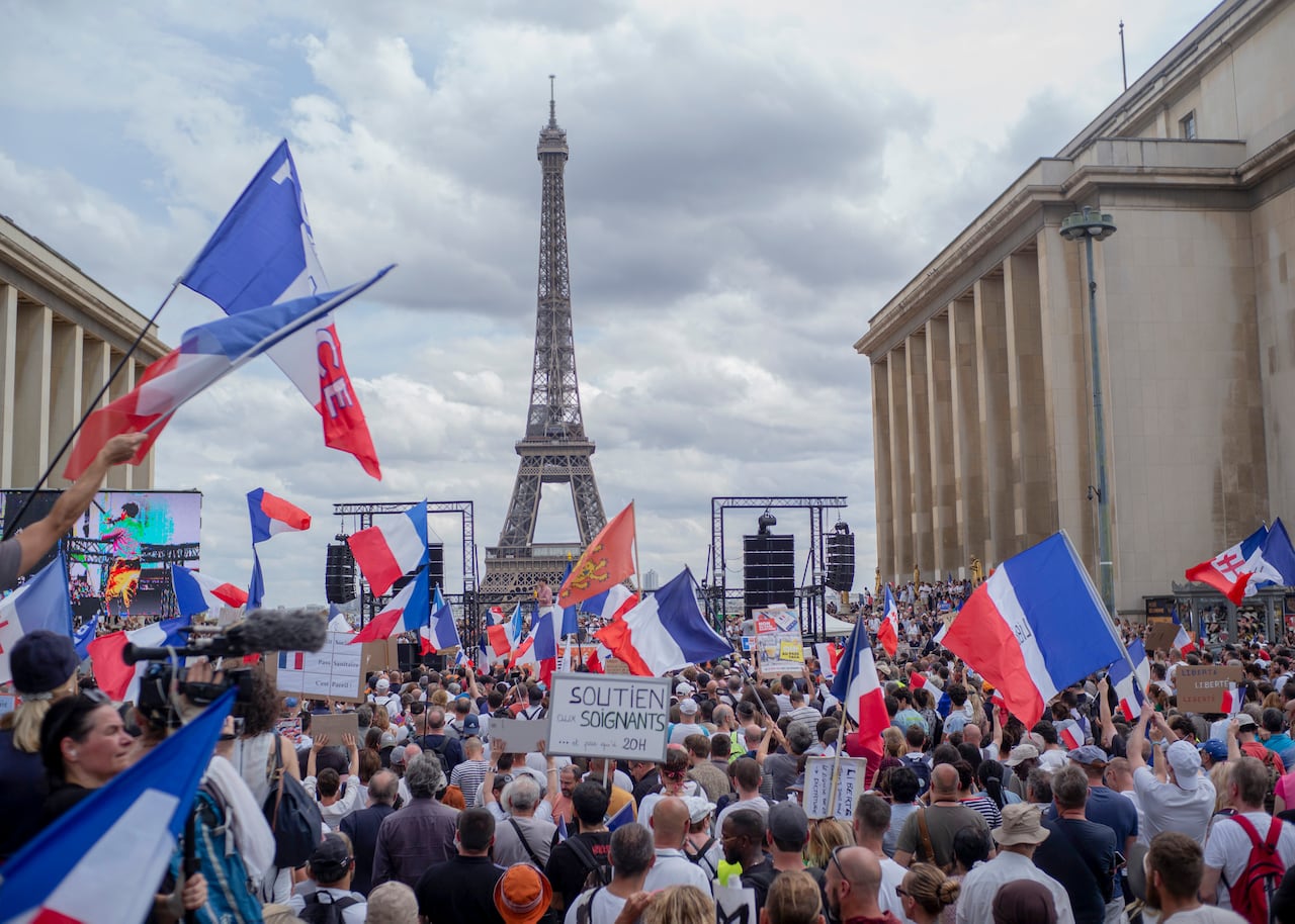 Miles de manifestantes se reúnen en la Place Trocadero cerca de la Torre Eiffel para asistir a una manifestación en París, Francia contra el pase COVID-19 que otorga a las personas vacunadas una mayor facilidad de acceso a los lugares. (Foto AP / Rafael Yaghobzadeh)