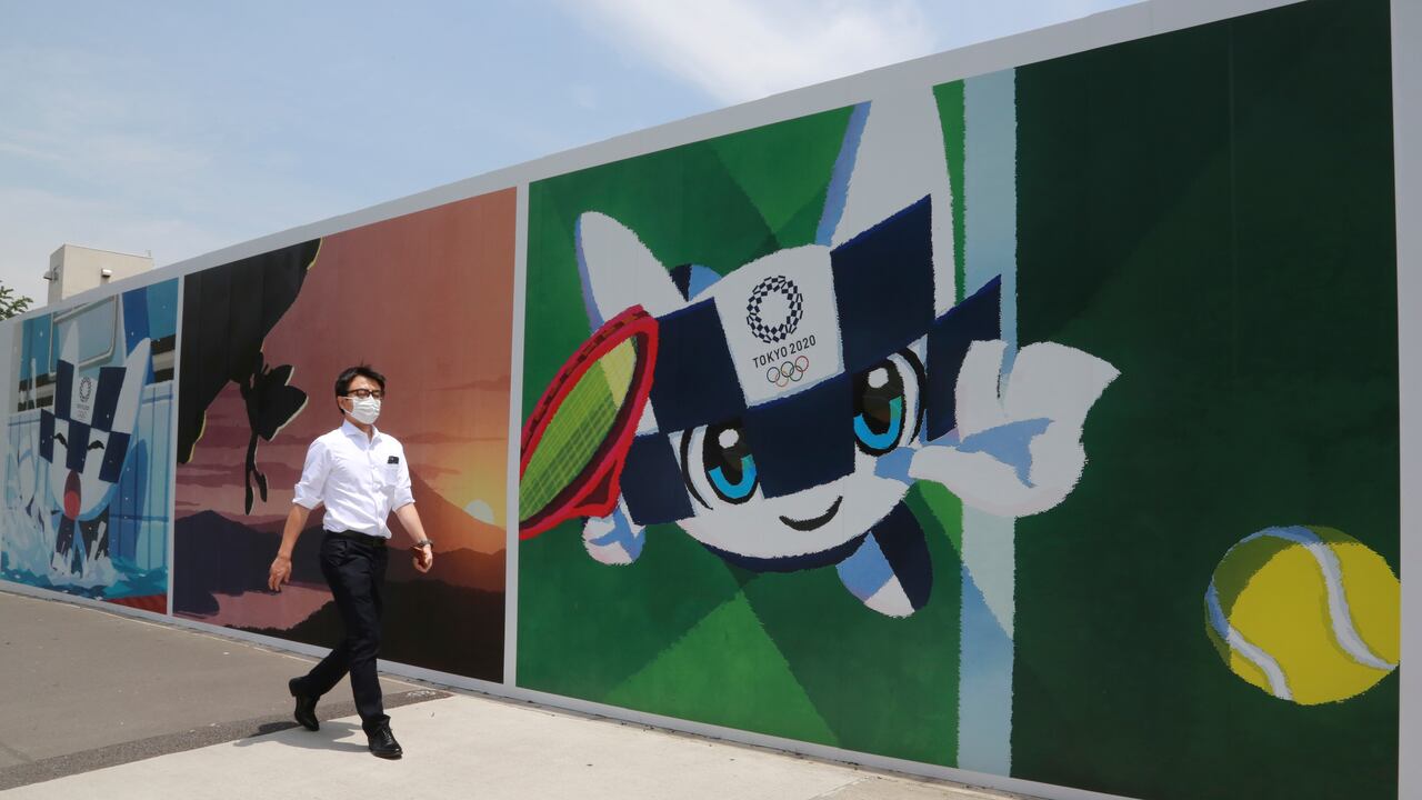 Un hombre camina frente a murales que promueven los Juegos Olímpicos, que están programados a iniciar en julio de 2021, el lunes 24 de mayo de 2021, en Tokio. (AP Foto/Koji Sasahara)