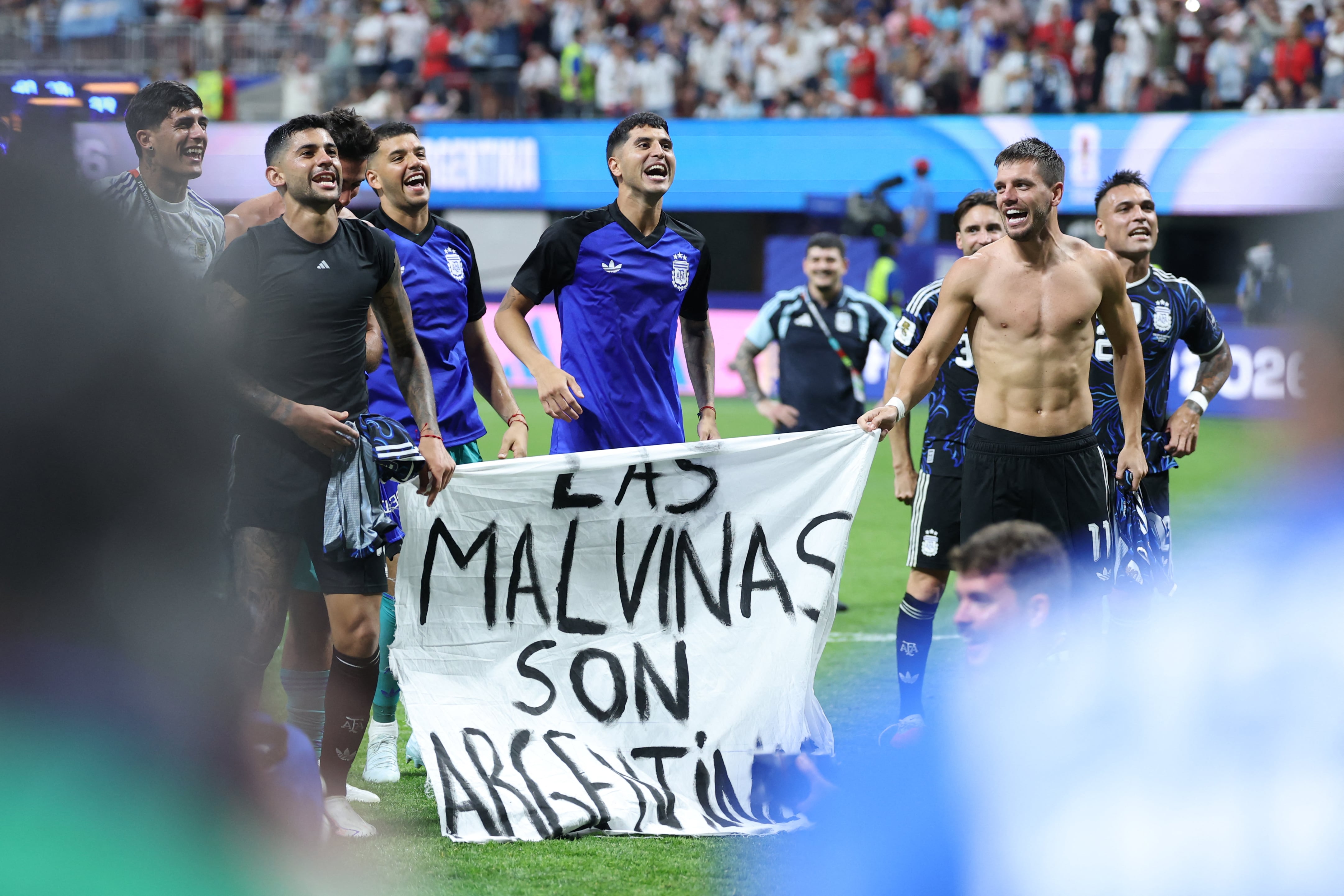 Argentina's players show a banner that reads in Spanish, "The Malvinas (Falkland Islands) belong to Argentina," after winning the 2026 World Cup football tournament semi-final match between England and Argentina at the Atlanta Stadium in Atlanta on July 15, 2026. (Photo by Thomas COEX / AFP)