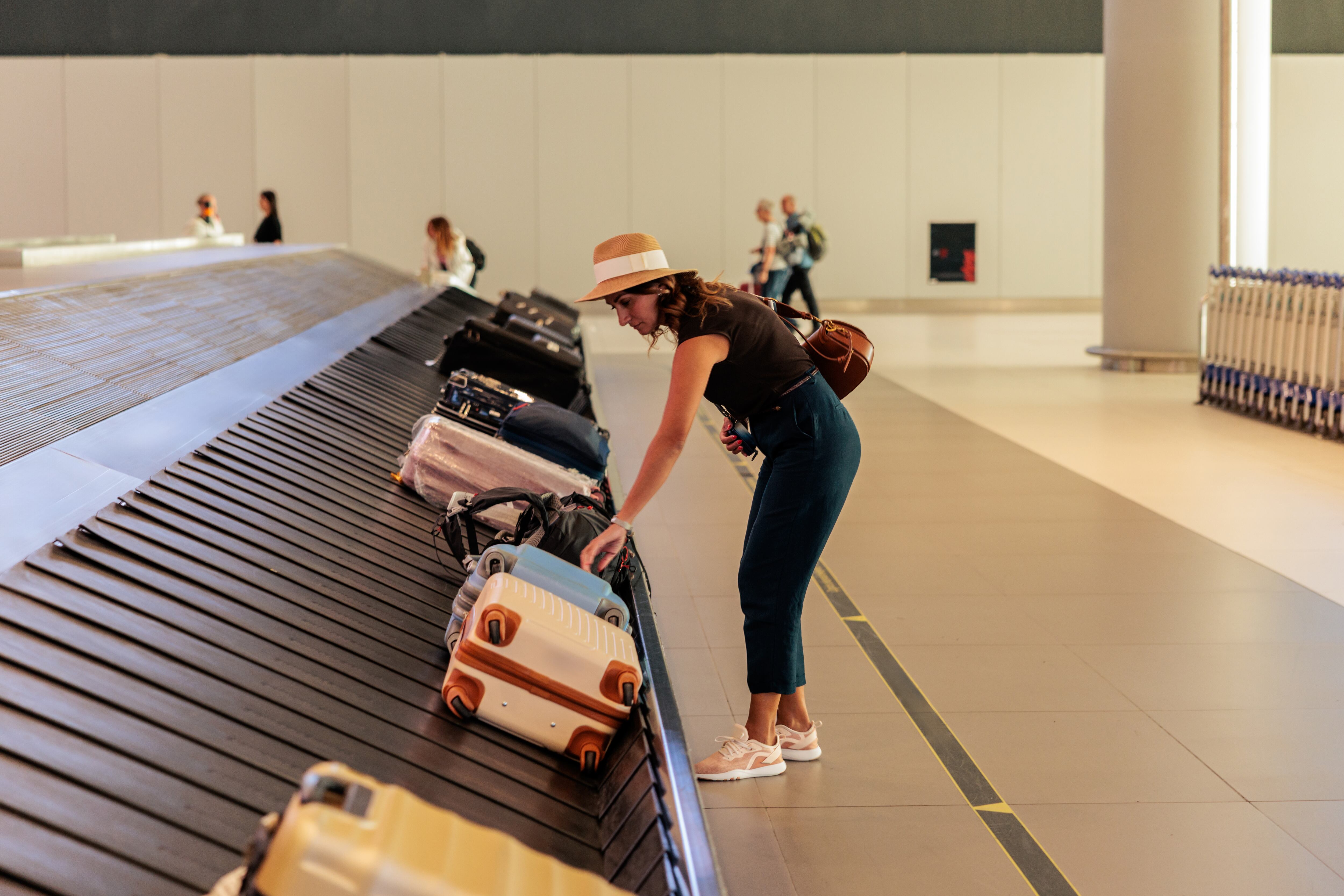 Mujer recogiendo su maleta en el aeropuerto