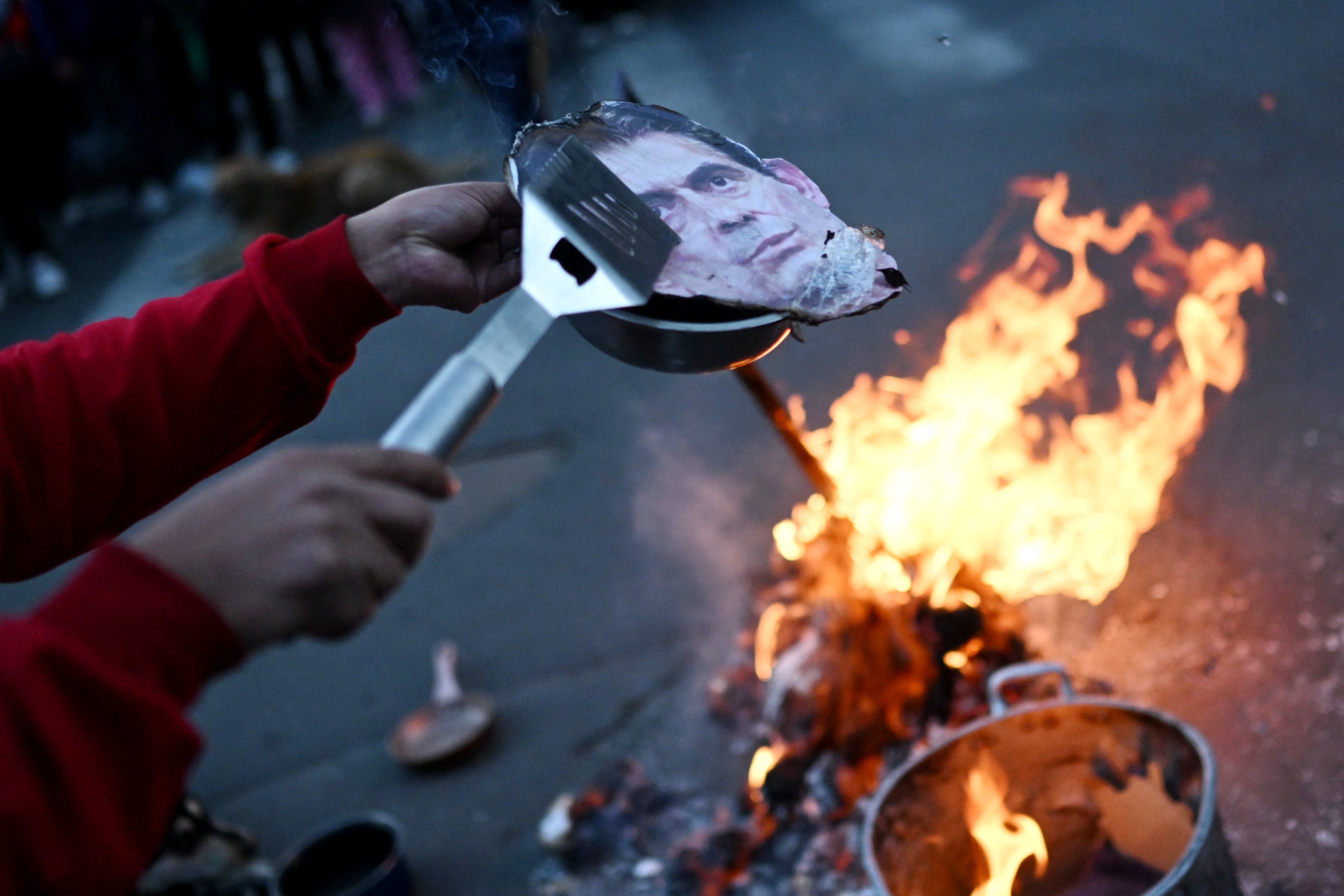 A demonstrator sets on fire a human-sized wooden figure depicting Bolivia's Rodrigo Paz during a protest against the government called by teachers in La Paz on May 27, 2026. Bolivian President Rodrigo Paz warned on May 27 that the crisis �is reaching a breaking point,� amid another day of demonstrations calling for his resignation, despite the possibility that he might declare a state of emergency to quell the protests. (Photo by Marvin RECINOS / AFP)