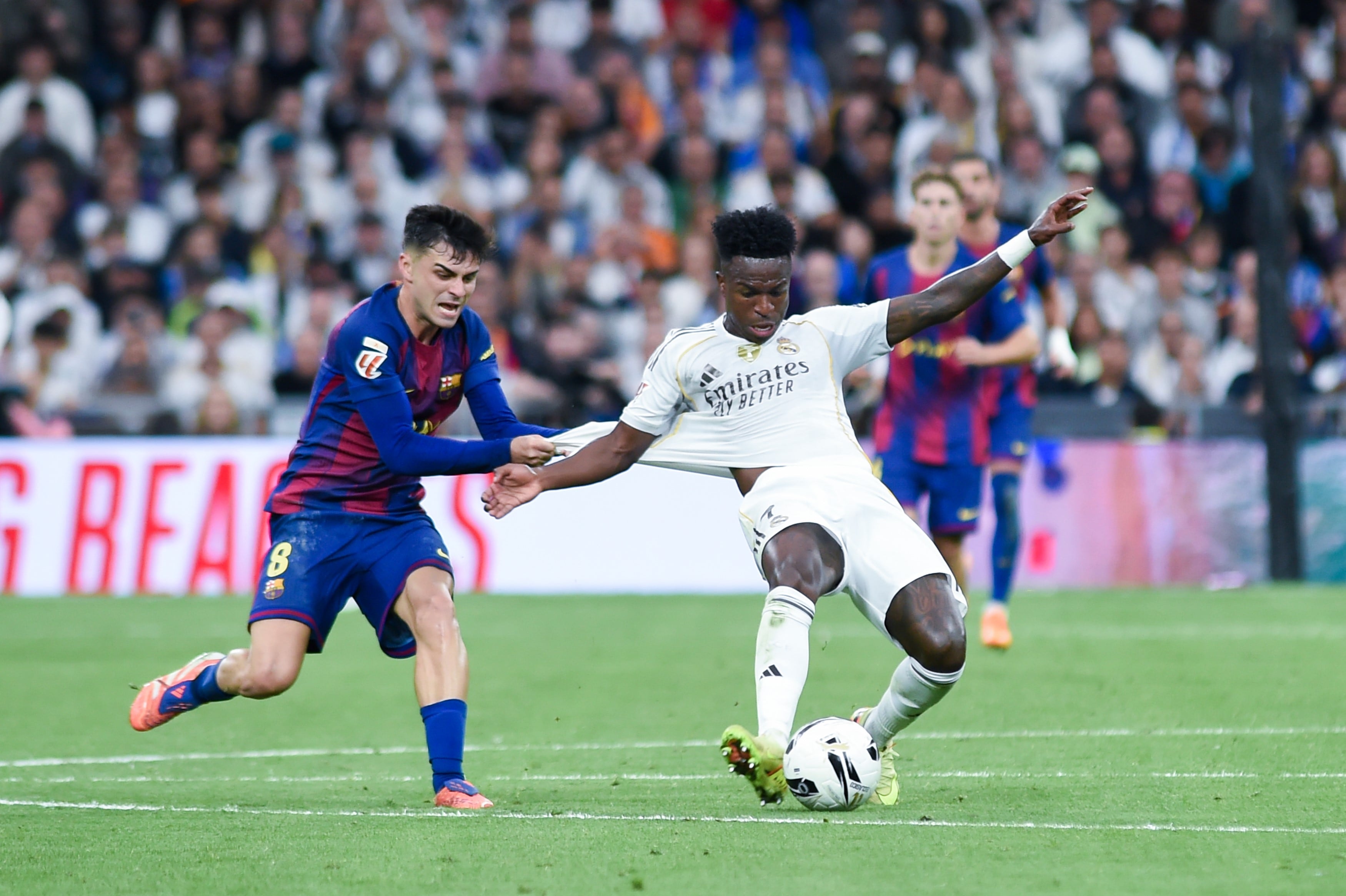 Vinicius Junior R of Real Madrid vies with Pedri of Barcelona during the La Liga football match between Real Madrid and FC Barcelona at Santiago Bernabeu Stadium in Madrid, Spain, on Oct. 26, 2025. (Photo by Gustavo Valiente/Xinhua via Getty Images)