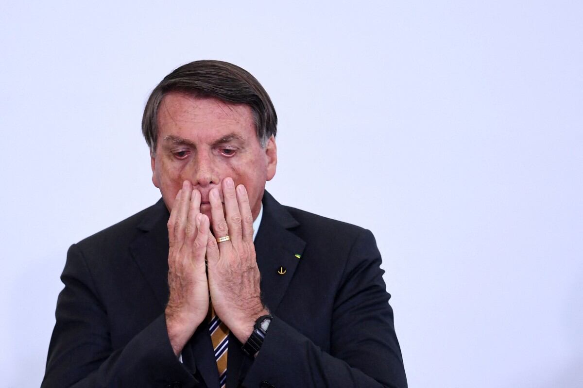 (FILES) Brazilian President Jair Bolsonaro gestures during the launch of a program for the resumption of tourism, a sector severely affected by the new coronavirus outbreak, at Planalto Palace in Brasilia, on November 10, 2020. Brazil's Supreme Court on September 11, 2025, convicted firebrand ex-president Jair Bolsonaro of plotting a coup, sealing his fate with a 4-1 vote that could send him to prison for the rest of his life. All but one judge found the 70-year-old guilty of plotting to overthrow Luiz Inacio Lula da Silva following his October 2022 elections defeat by the left-winger. (Photo by EVARISTO SA / AFP)