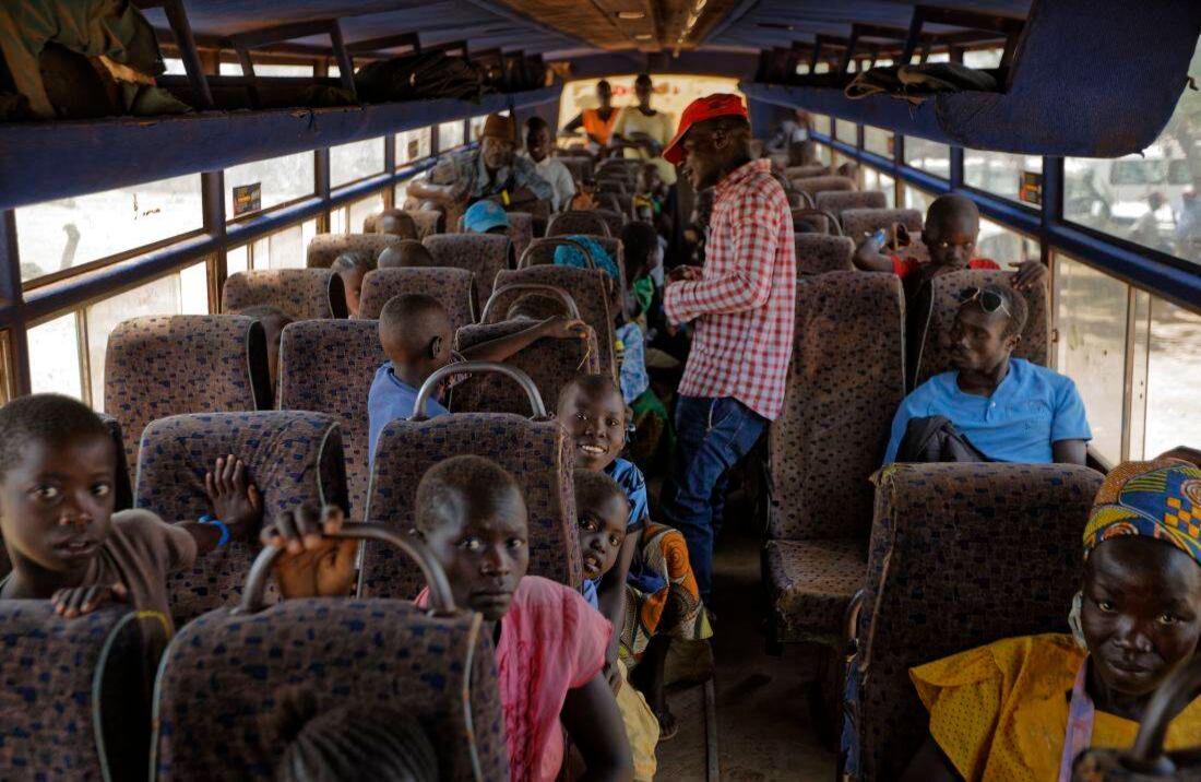 Los refugiados sudaneses que recientemente cruzaron la frontera se sientan en un autobús que los lleva al centro de recepción de Imvepi, (Foto de AP / Ben Curtis)  