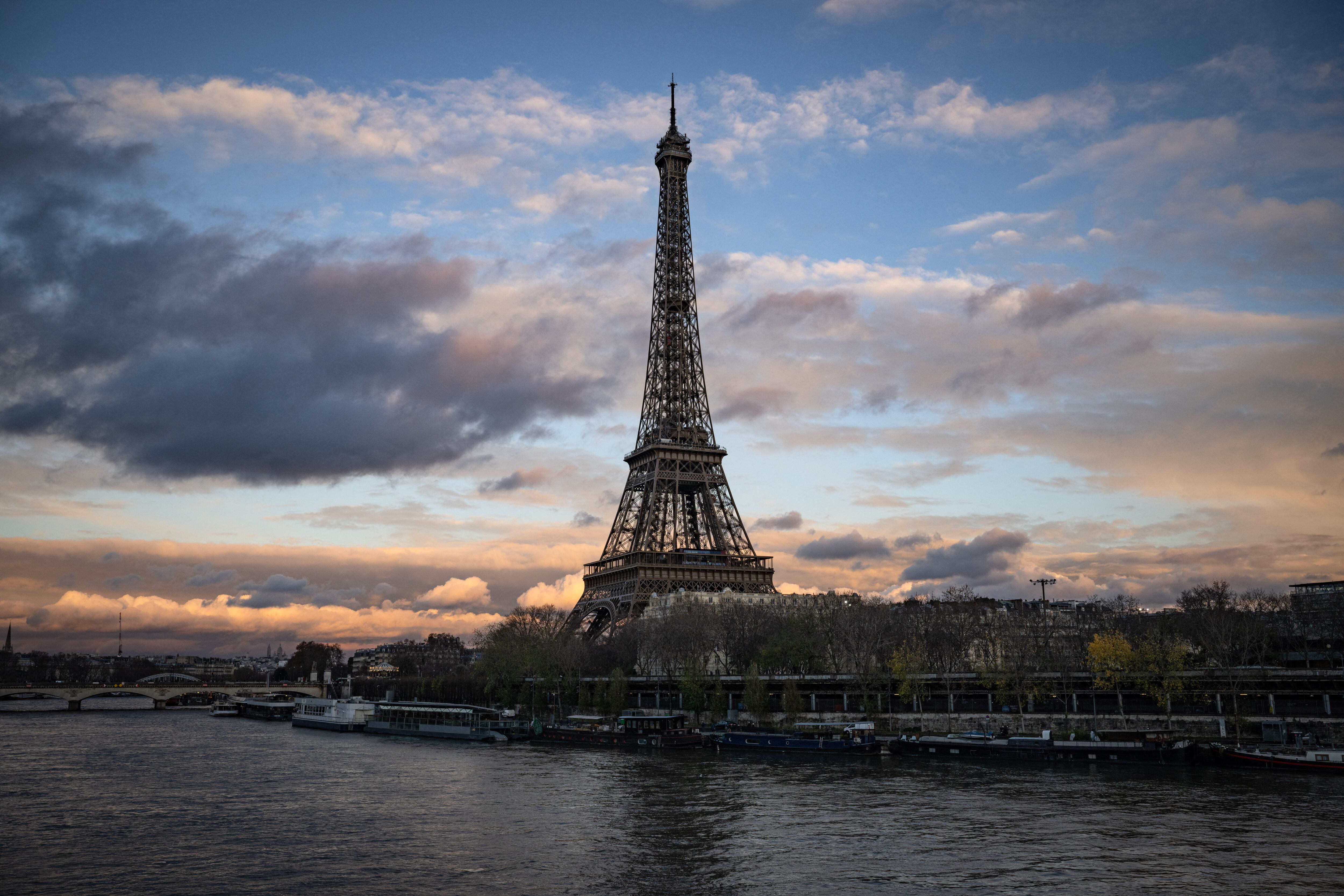 (Esta fotografía tomada el 5 de diciembre de 2023 muestra una vista general de la Torre Eiffel a lo largo del río Sena en París. Los organizadores de los Juegos Olímpicos y Paralímpicos de París (del 26 de julio al 8 de septiembre) están sudando frío por este compromiso: El éxito de las pruebas de natación en el Sena depende de la calidad de su agua, que, aunque ha mejorado, todavía no será satisfactoria en el verano de 2023. (Foto de MIGUEL MEDINA / AFP)
