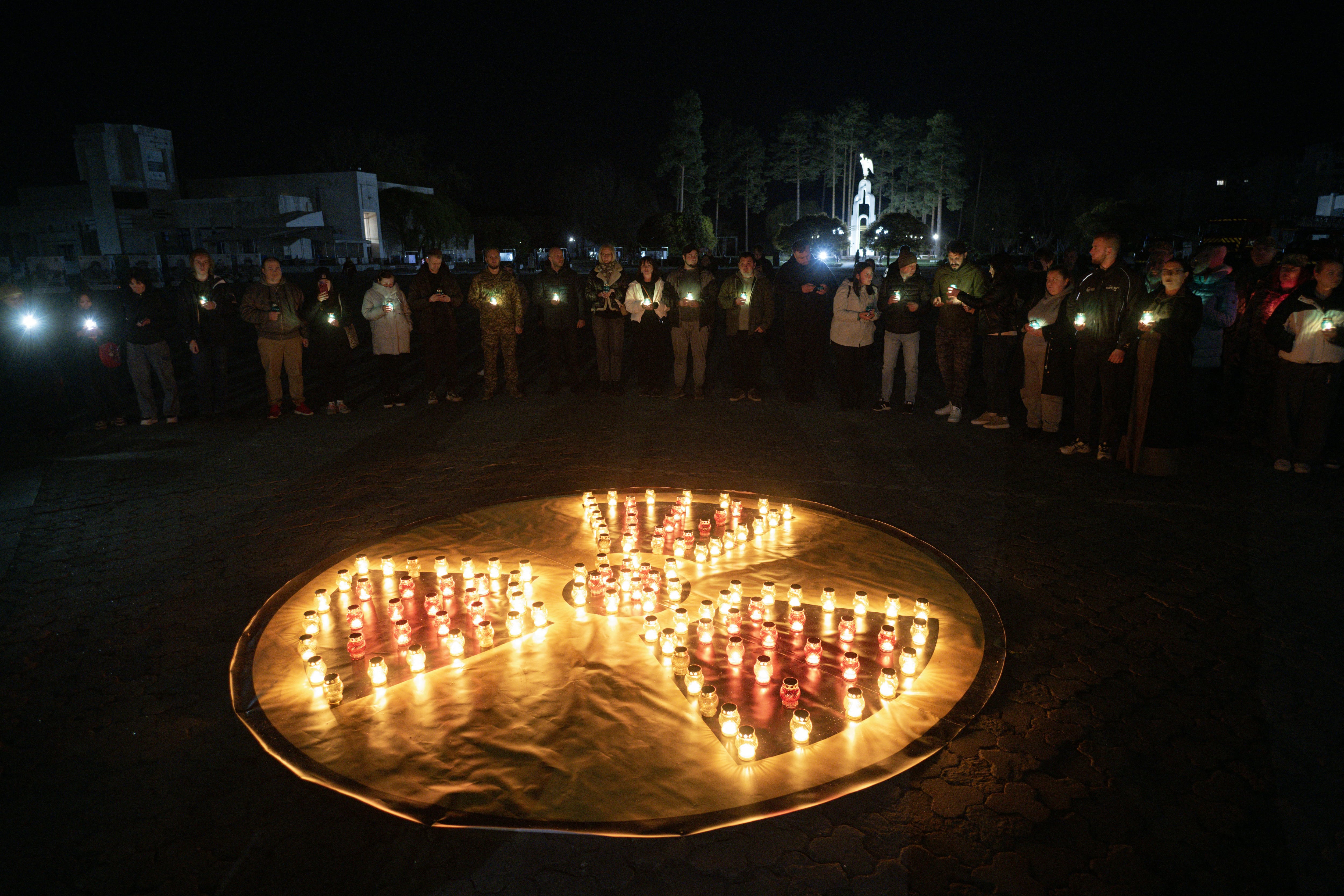 Personas frente a un monumento a las víctimas de Chernóbil en la ciudad de Slavutych, el 25 de abril de 2026, en medio de la invasión rusa de Ucrania.
