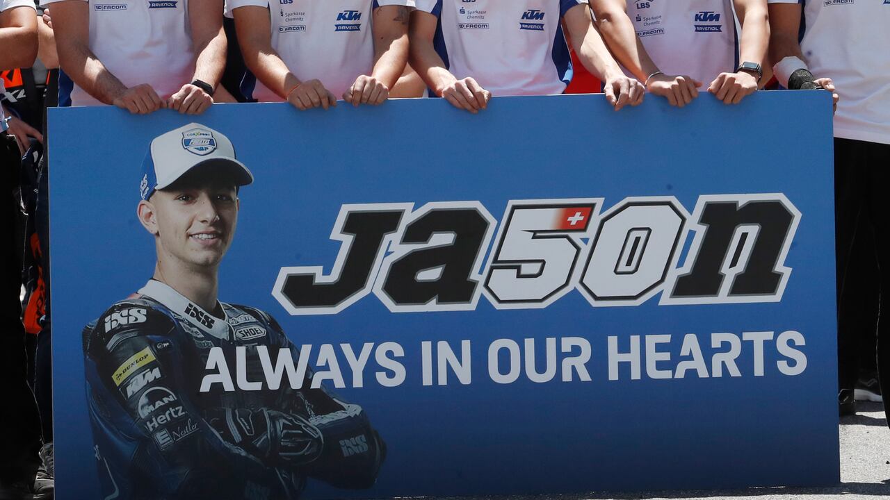 Los compañeros del piloto suizo de 19 años Jason Dupasquier hacen un minuto de silencio en su memoria antes del inicio del Gran Premio de Italia de Motogp.(Foto AP / Antonio Calanni)