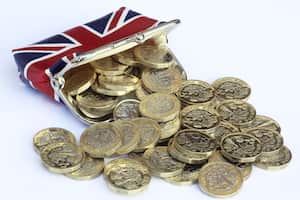 Monedas de una libra recién acuñadas saliendo del bolso con un diseño de Reino Unido.