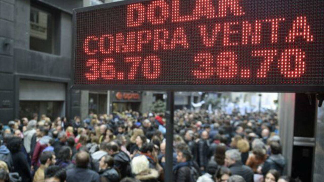 Cada vez que el peso se devalúa en Argentina, las casas de cambio se llenan de gente que busca proteger su ahorros cambiando a dólares. (AFP)