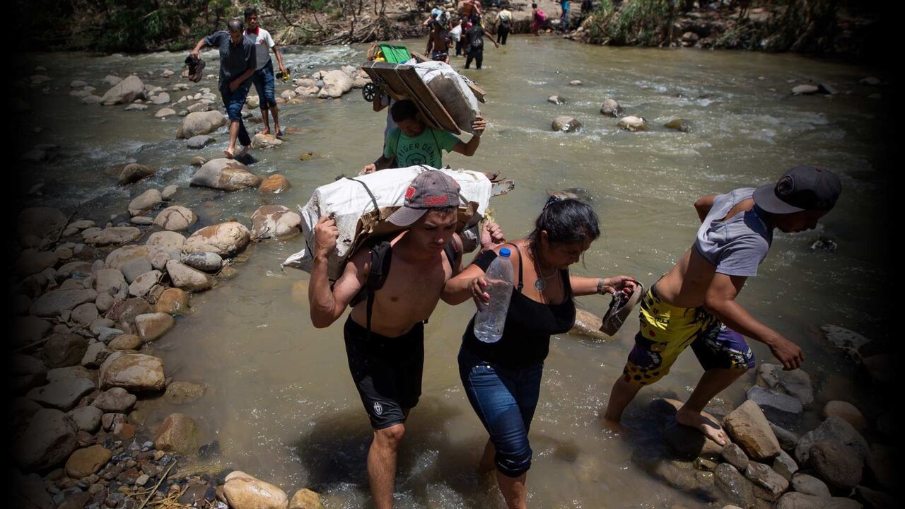 Migrantes venezolanos cruzan hacia Colombia por las trochas.