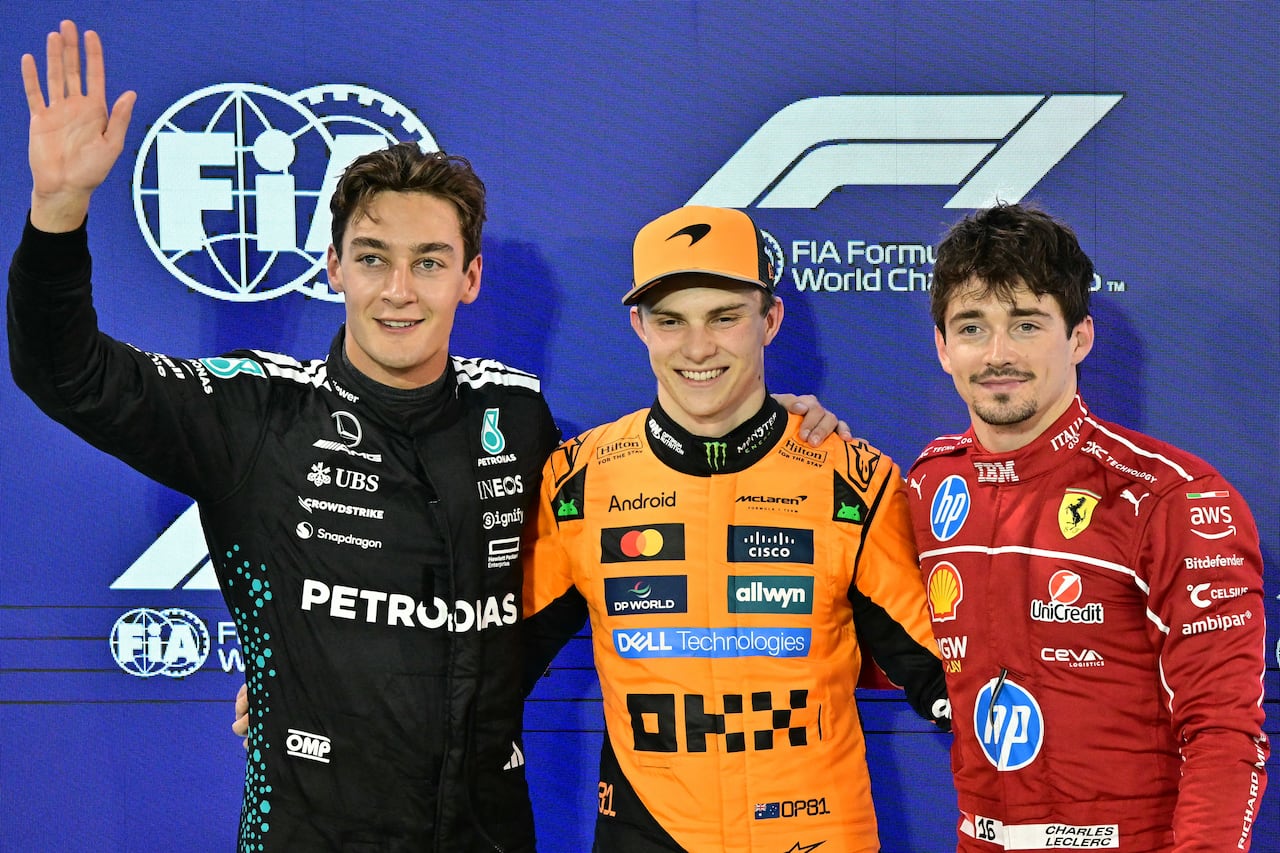 Mercedes' British driver George Russell, McLaren's Australian driver Oscar Piastri and Ferrari's Monegasque driver Charles Leclerc pose after the qualifying session ahead of the Bahrain Formula One Grand Prix at the Bahrain International Circuit in Sakhir on April 12, 2025. (Photo by Giuseppe CACACE / AFP)