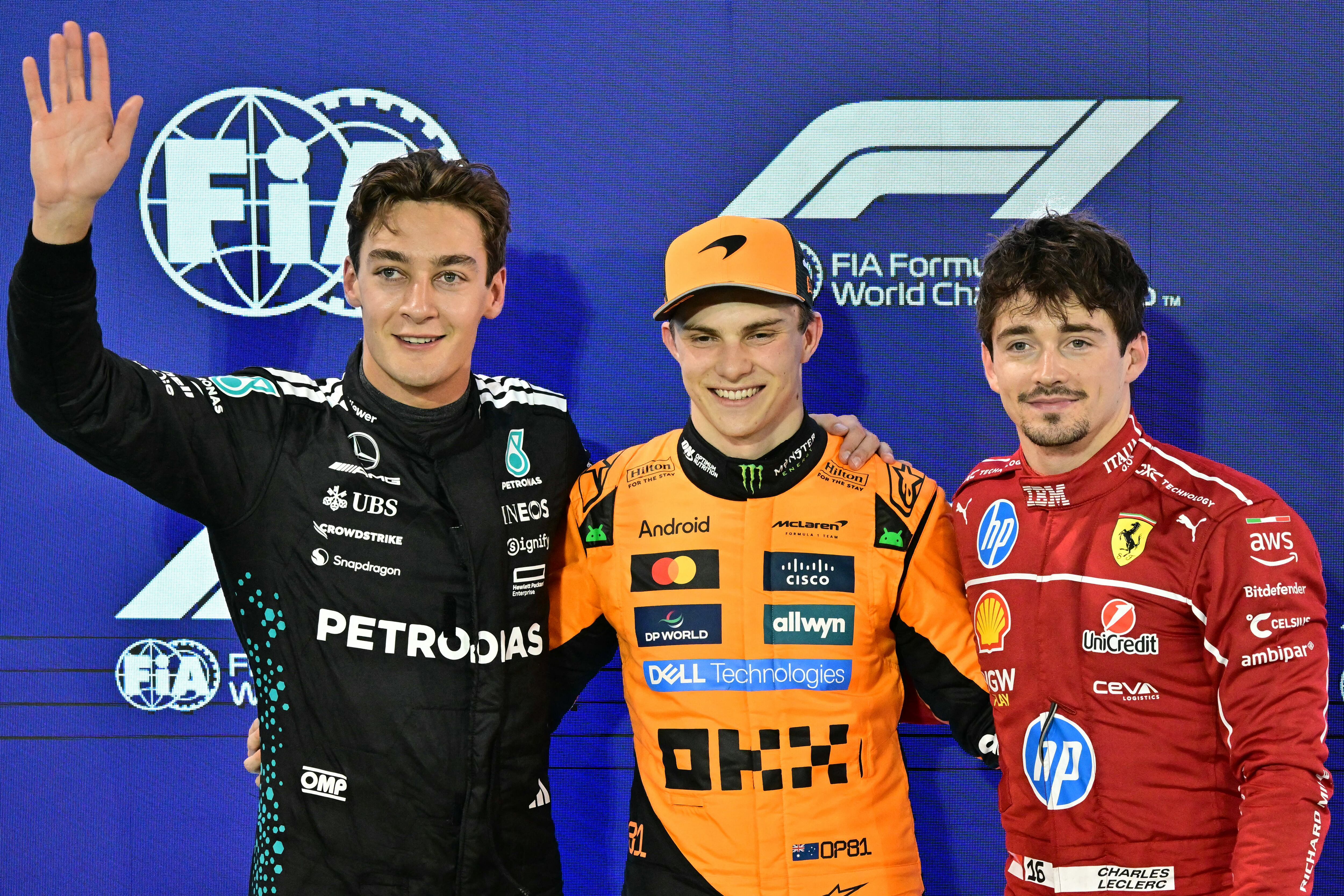 Mercedes' British driver George Russell, McLaren's Australian driver Oscar Piastri and Ferrari's Monegasque driver Charles Leclerc pose after the qualifying session ahead of the Bahrain Formula One Grand Prix at the Bahrain International Circuit in Sakhir on April 12, 2025. (Photo by Giuseppe CACACE / AFP)
