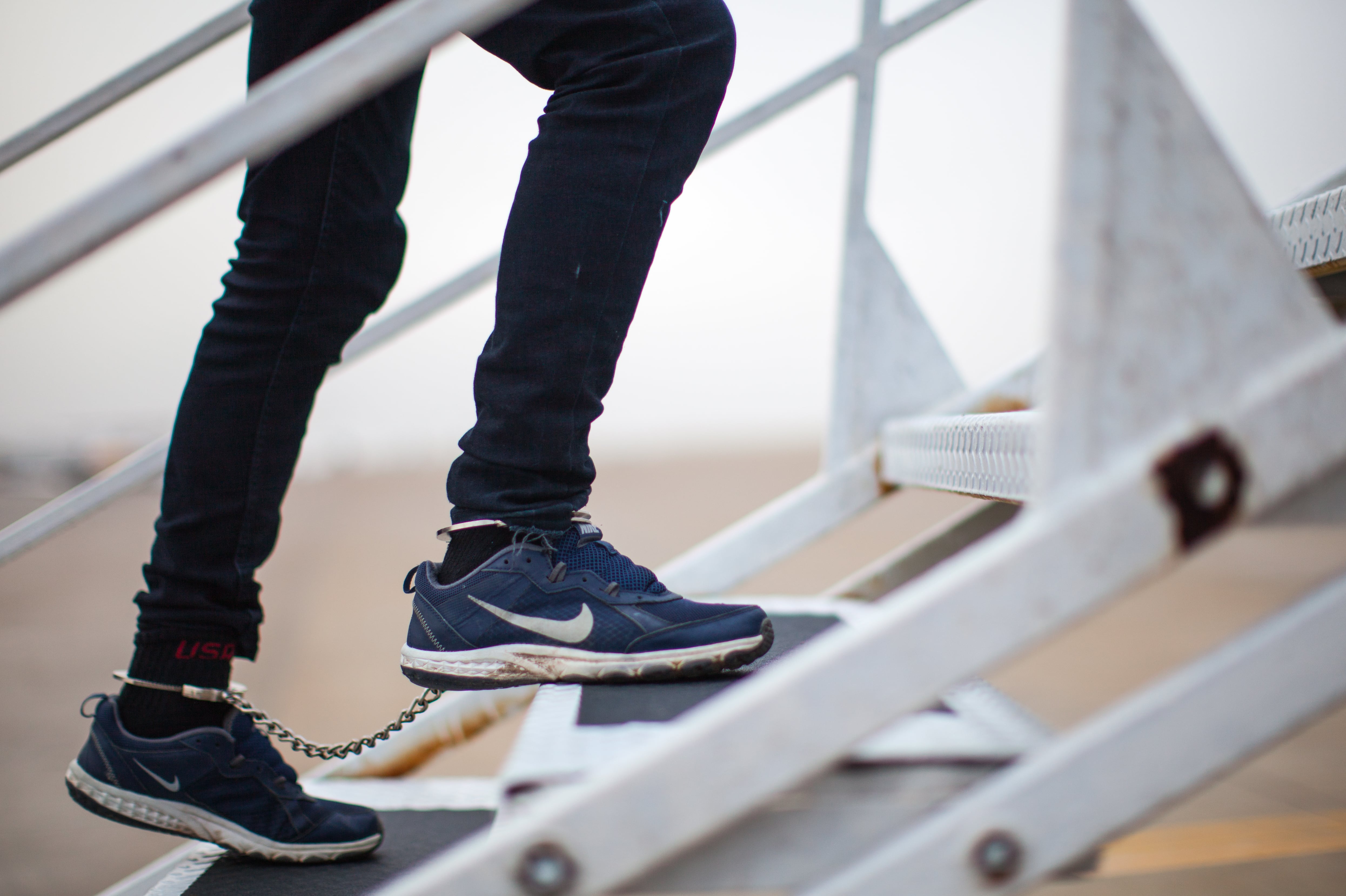 An illegal alien board a plane for a removal flight.