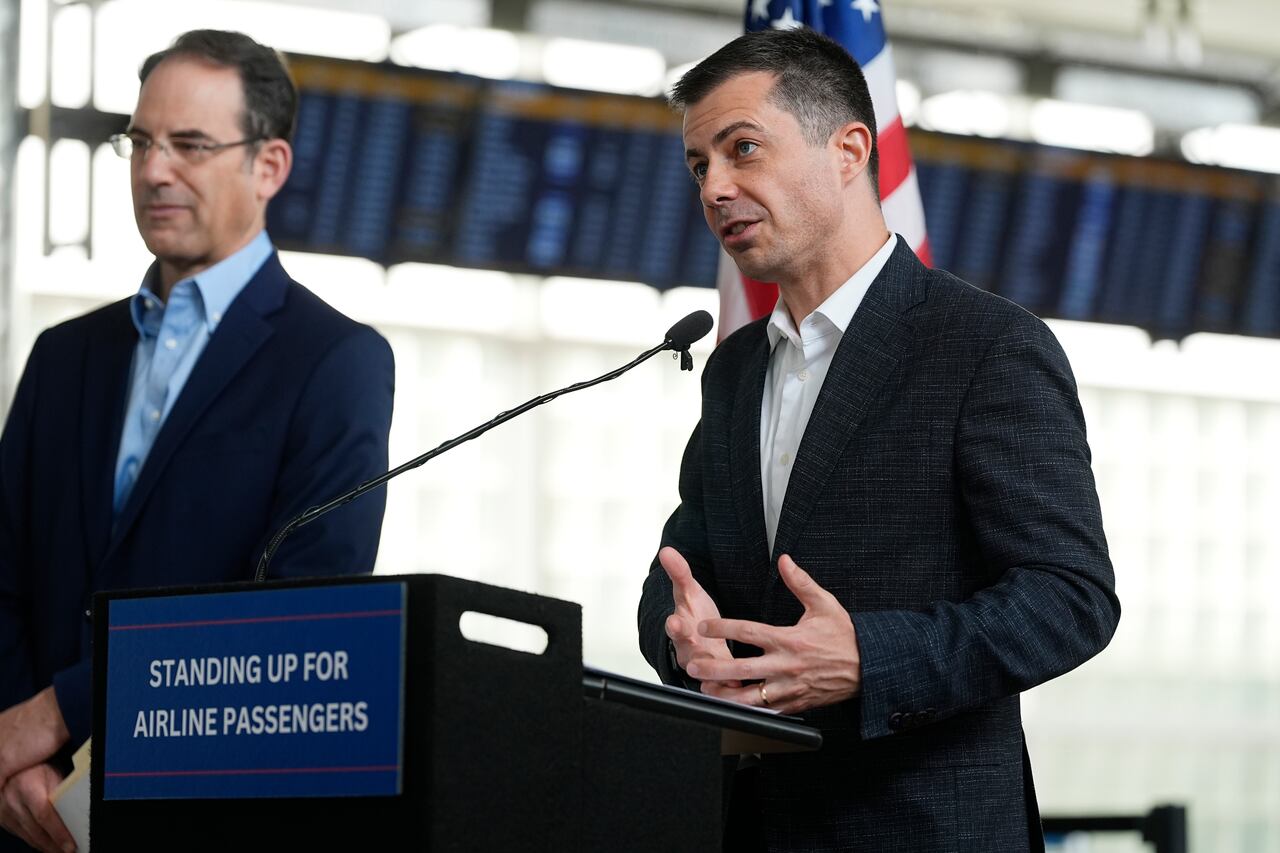 El Secretario de Transporte de los Estados Unidos, Pete Buttigieg, habla mientras el Fiscal General de Colorado, Phil Weiser, escucha durante una conferencia de prensa para anunciar una nueva asociación que agilizará la forma en que se resuelven las quejas de los consumidores contra las aerolíneas en la terminal del Aeropuerto Internacional de Denver el martes 16 de abril de 2024 en Denver.