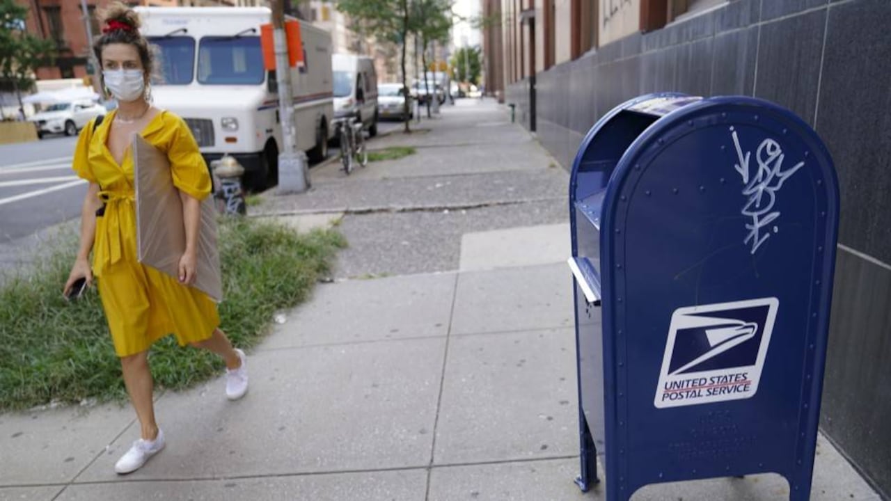 Una mujer pasa junto a un buzón del servicio postal en Nueva York.
