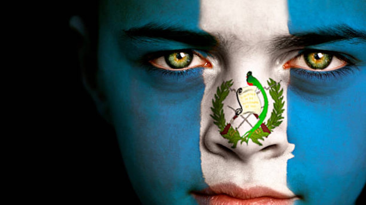 Retrato de un niño con la bandera de Guatemala pintada en su cara