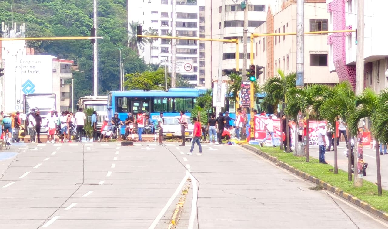 Agentes de tránsito regulan el flujo vehicular en la Calle 5 con Carrera 5, donde un bloqueo genera fuerte congestión en ambos sentidos.