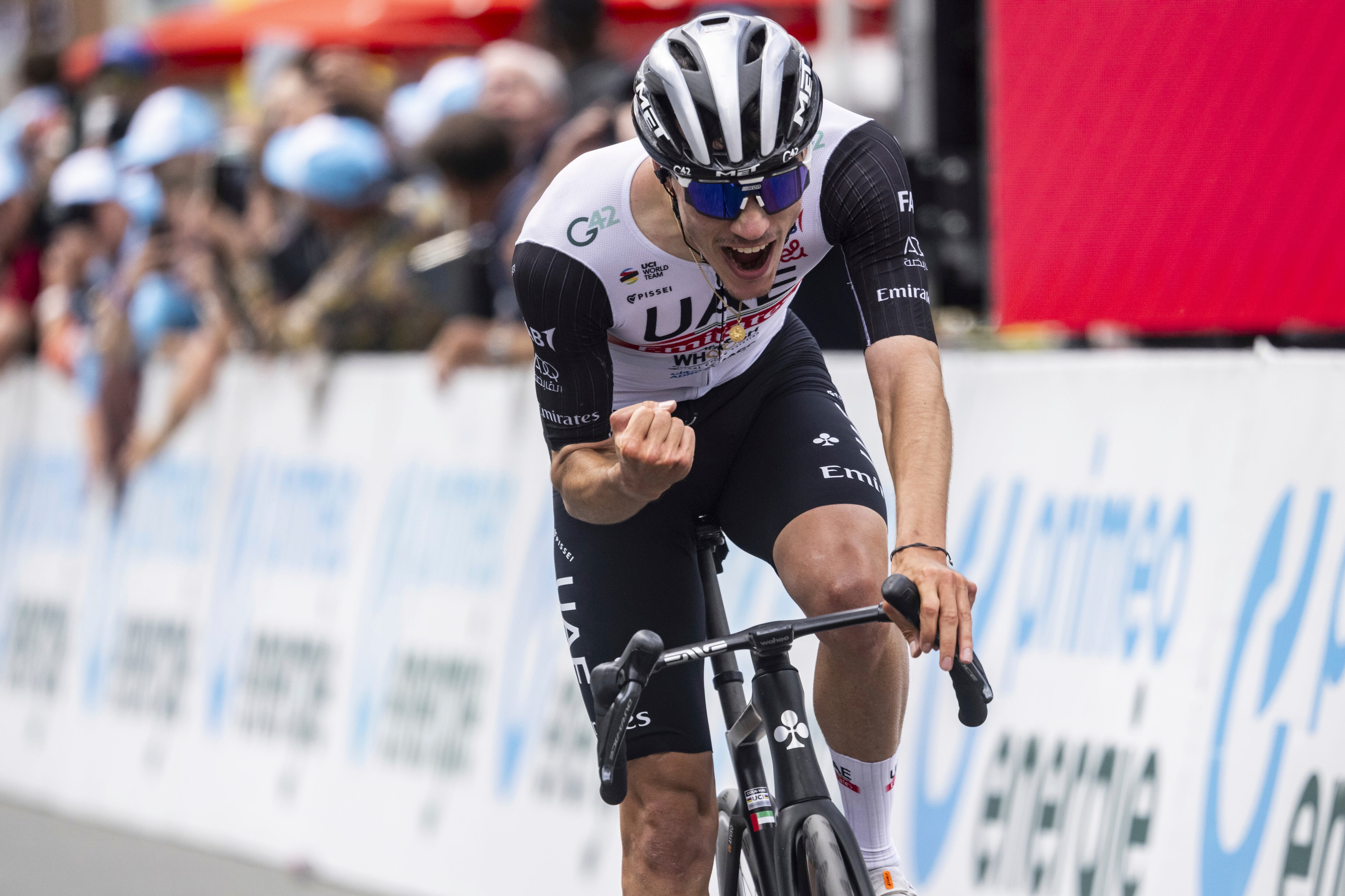 Juan Ayuso from Spain of UAE Team Emirates celebrates crossing the finish line as the winner of the fifth stage, a 211 km race from Fiesch to La Punt, of the 86th Tour de Suisse UCI World Tour cycling race in Goms, Switzerland, Thursday, June 15, 2023. (Gian Ehrenzeller/Keystone via AP)