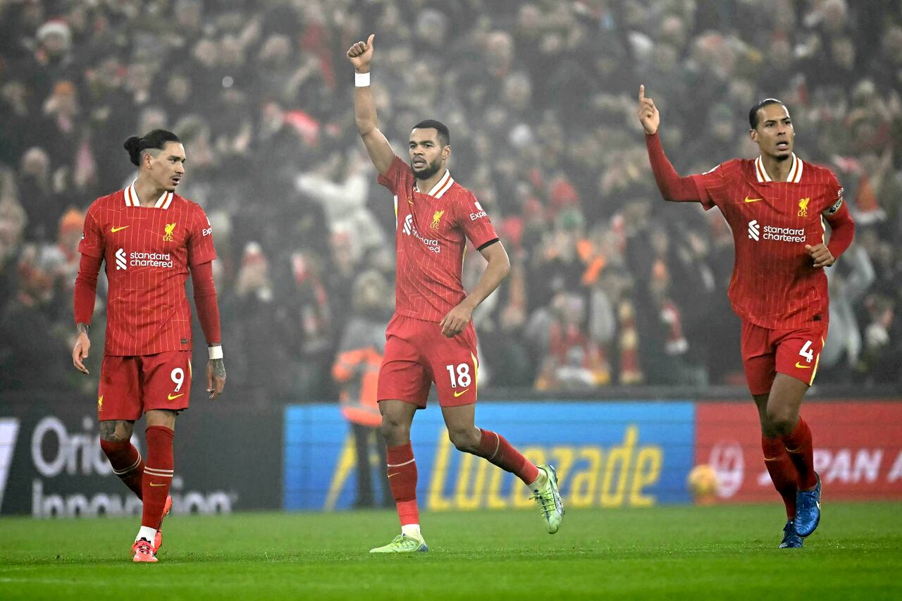 Liverpool's Dutch striker #18 Cody Gakpo (C) celebrates after scoring the equalising goal during the English Premier League football match between Liverpool and Leicester City at Anfield in Liverpool, north west England on December 26, 2024. (Photo by Paul ELLIS / AFP) / RESTRICTED TO EDITORIAL USE. No use with unauthorized audio, video, data, fixture lists, club/league logos or 'live' services. Online in-match use limited to 120 images. An additional 40 images may be used in extra time. No video emulation. Social media in-match use limited to 120 images. An additional 40 images may be used in extra time. No use in betting publications, games or single club/league/player publications. /