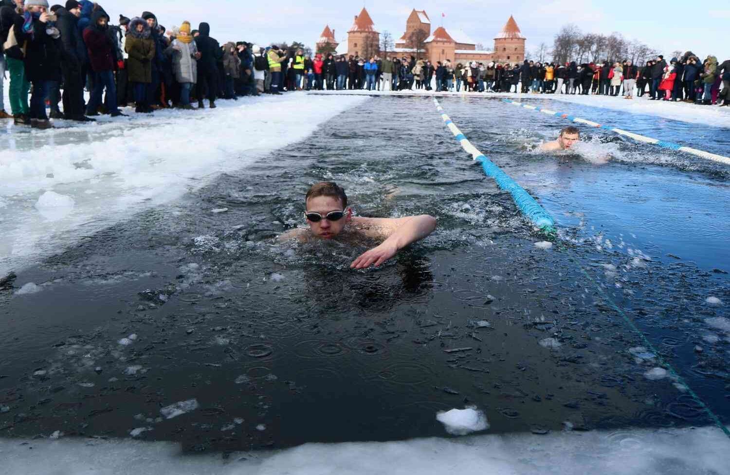 Las personas participan en una competencia anual de natación de invierno en aguas heladas, con temperaturas que bajan a menos 12 grados centígrados, el 24 de febrero de 2018 en Trakai, Lituania. Petras Malukas / AFP