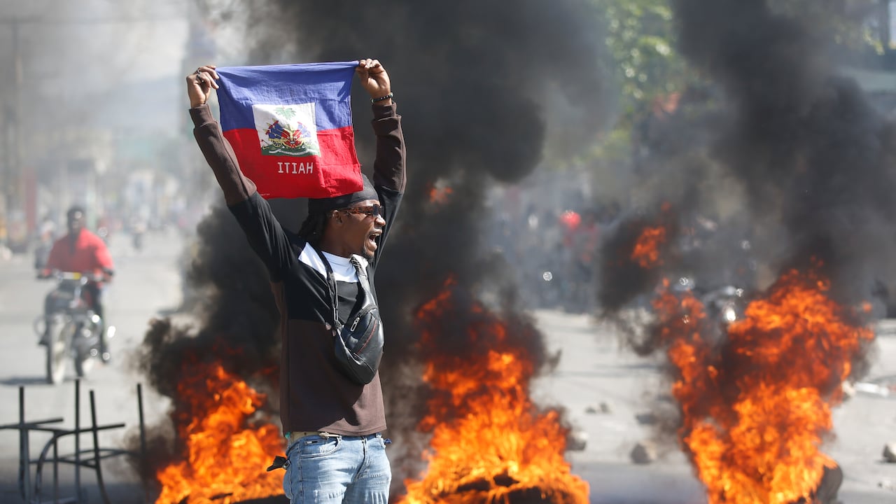 Un manifestante muestra una bandera haitiana durante una protesta para exigir la renuncia del primer ministro del país, Ariel Henry, en Puerto Príncipe, Haití, el 1 de marzo de 2024. (AP Foto/Odelyn Joseph)