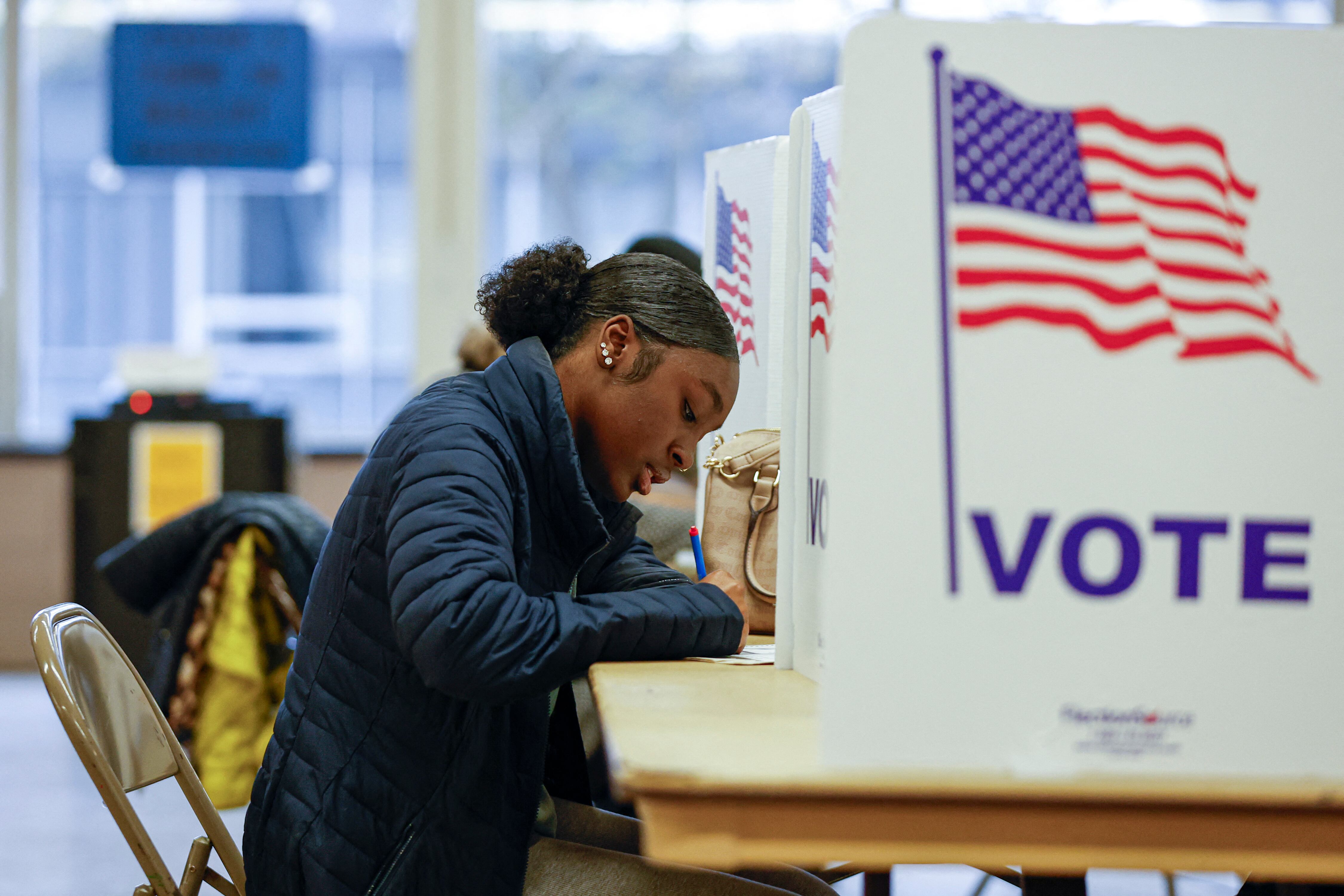 Una mujer emite su voto durante la votación anticipada para las elecciones generales de Estados Unidos en un colegio electoral de la escuela secundaria Ottawa Hills en Grand Rapids, Michigan