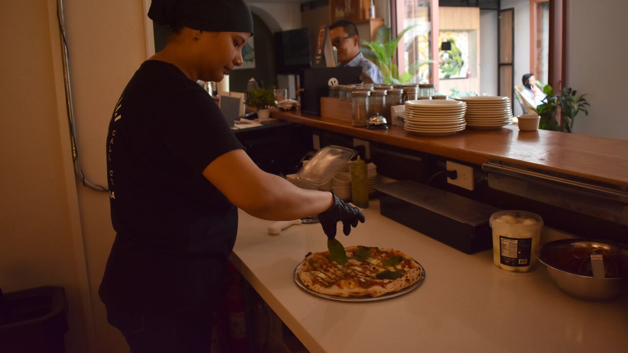 La pizza es preparada con múltiples ingredientes importados.