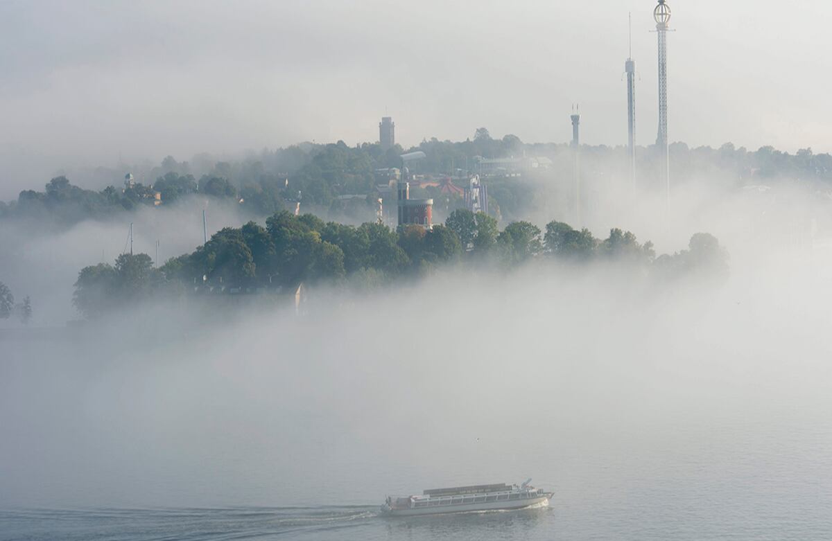 Un bote de turistas atraviesa la niebla de la mañana en el muelle de Estocolmo. (AP)