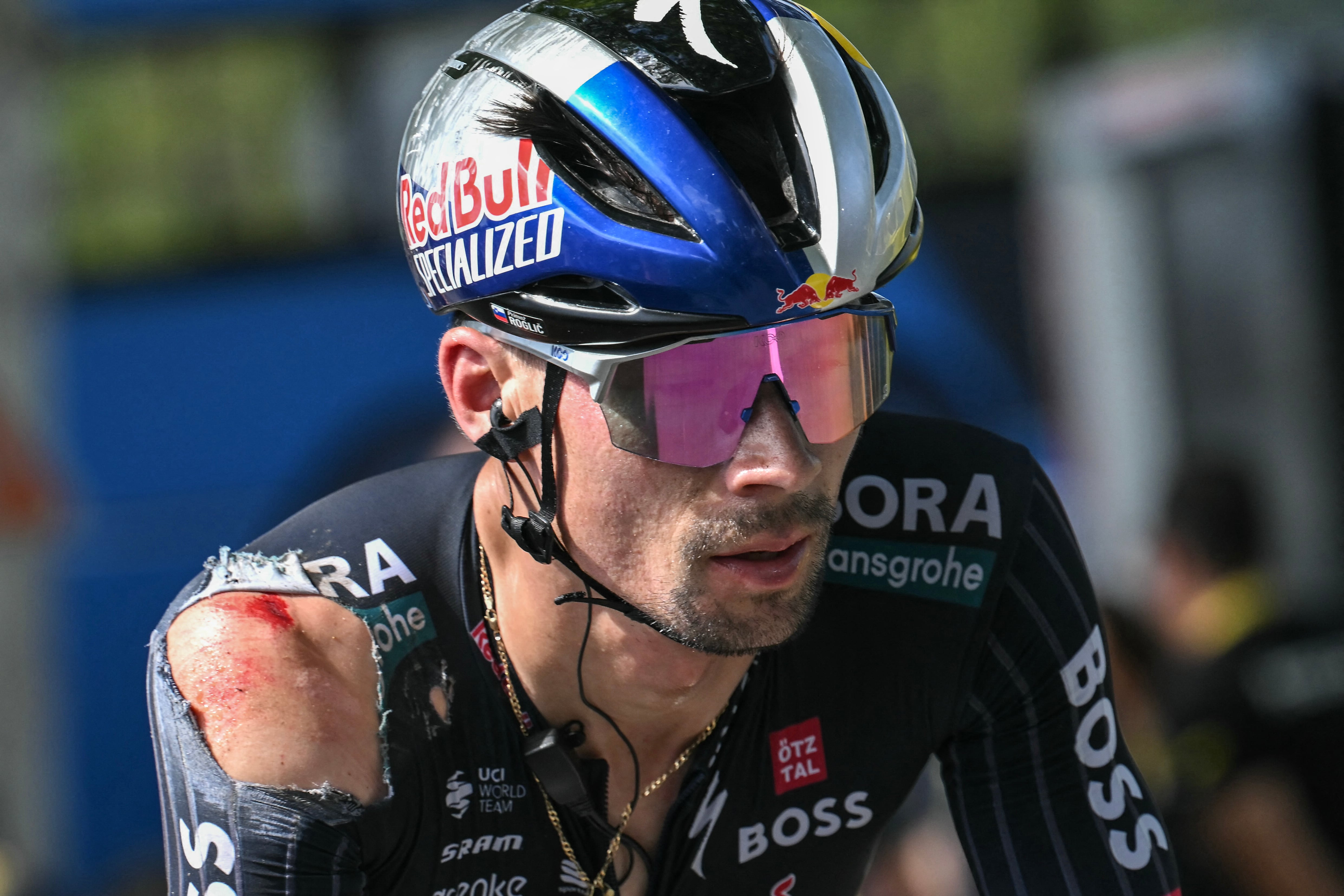 (FILES) Red Bull - BORA - hansgrohe team's Slovenian rider Primoz Roglic, with visible injuries sustained in a crash in the final kilometers of the stage, cycles past the finish line of the 12th stage of the 111th edition of the Tour de France cycling race, 203,6 km between Aurillac and Villeneuve-sur-Lot, southwestern France, on July 11, 2024. Leading contender Primoz Roglic has withdrawn from the Tour de France before the start of stage 13, his team Red Bull Bora Hansgrohe said on July 12, 2024. (Photo by Marco BERTORELLO / AFP)