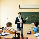 A teacher wearing a N95 Face masks teaches mathematics at an High School